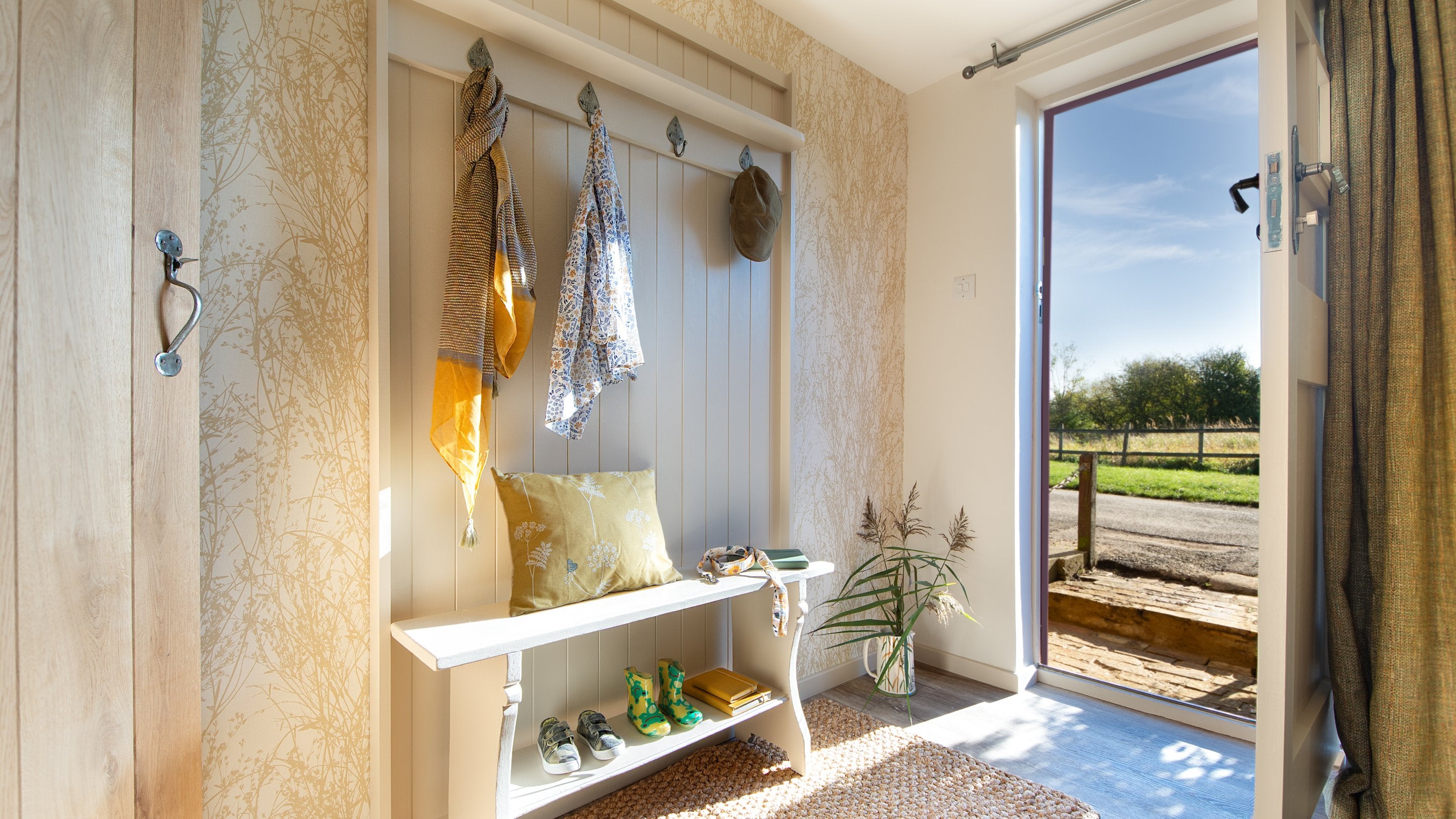 The front entrance to Cladium opens into the dining room, with a shoe bench and pegs, Cambridgeshire