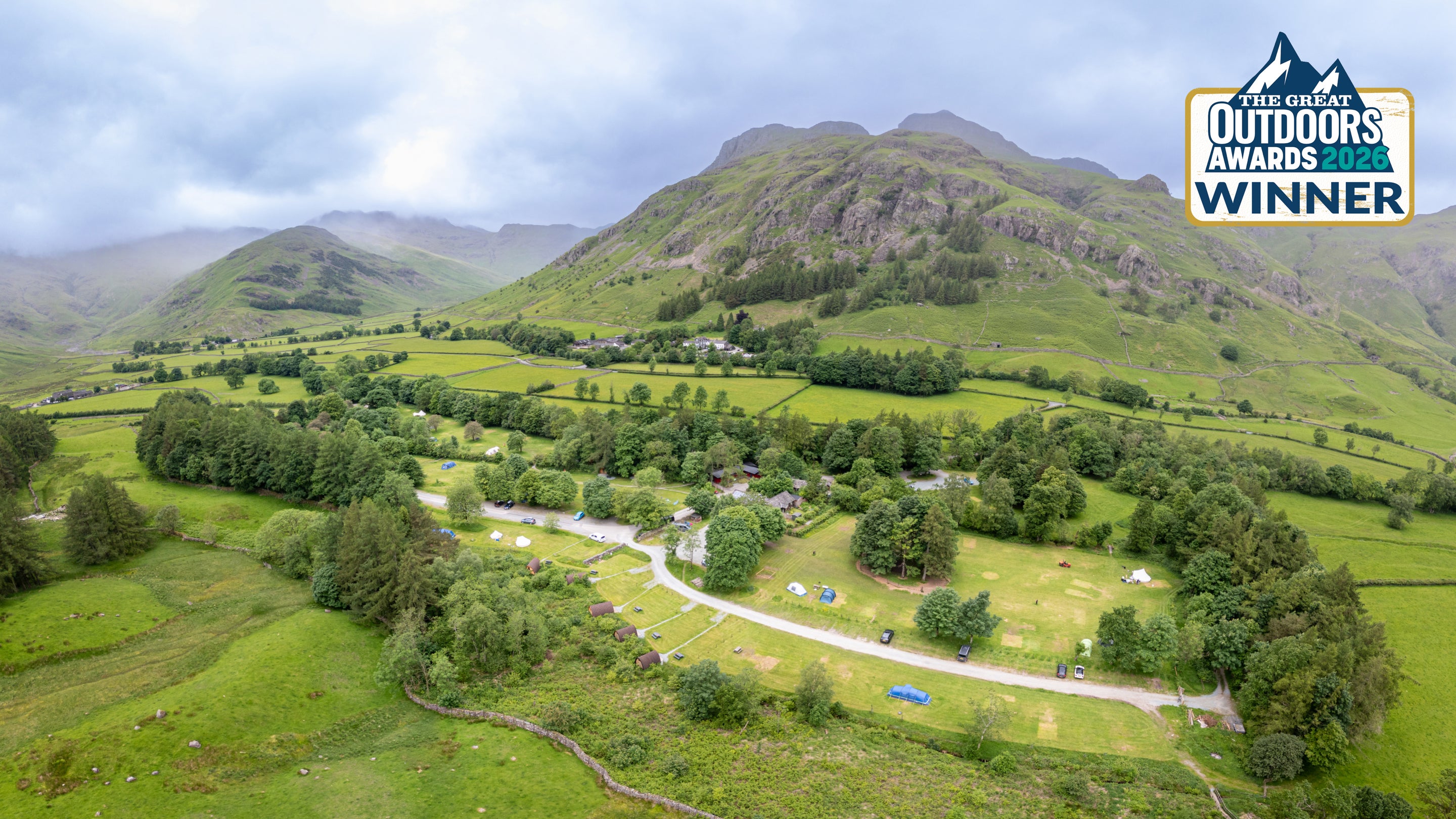 An aerial view of Great Langdale Campsite, with a logo in the top right corner reading The Great Outdoors Awards 2026 Winner, Cumbria