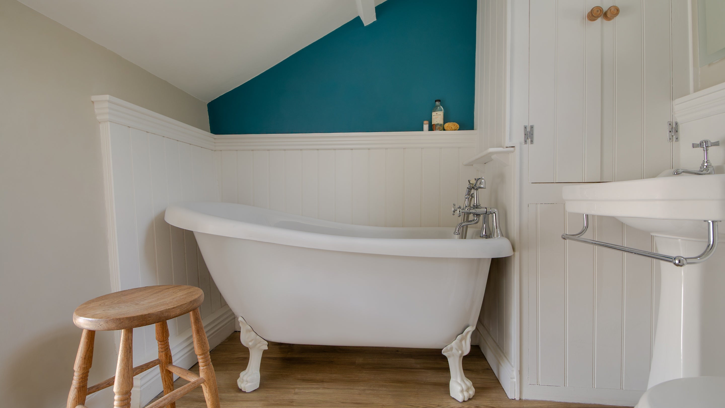 The bathroom on the ground floor of The Birdcage, with roll-top bath with with shower attachment, Cornwall