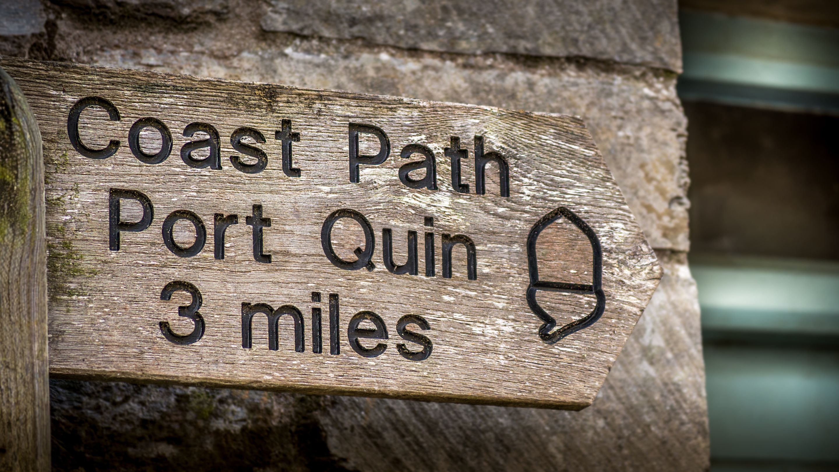 A sign for the South West Coast Path, showing a three-mile route from Port Isaac to Port Quin, Cornwall
