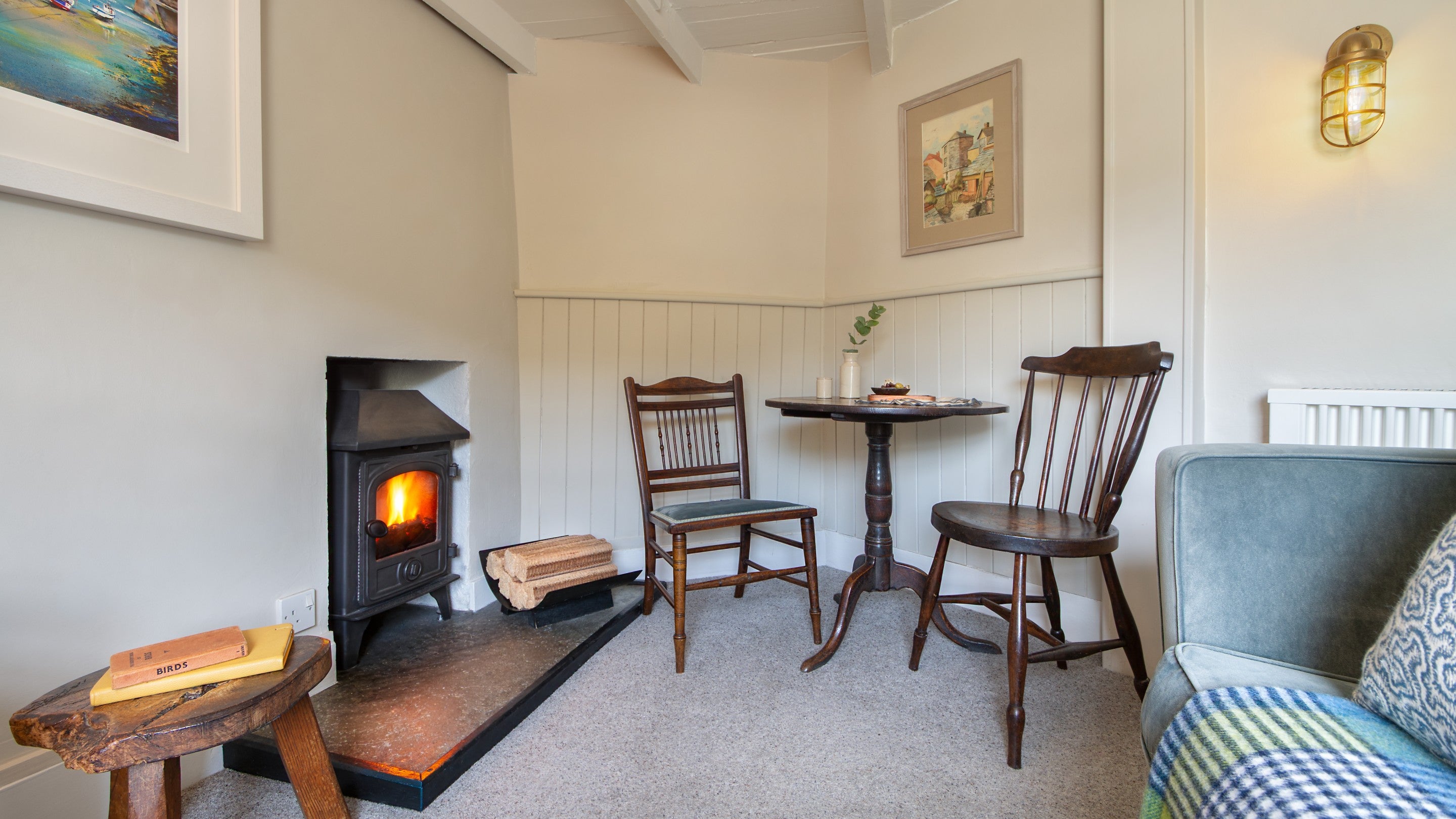 The dining table for two and woodburner in the sitting room on the first floor of The Birdcage, Cornwall