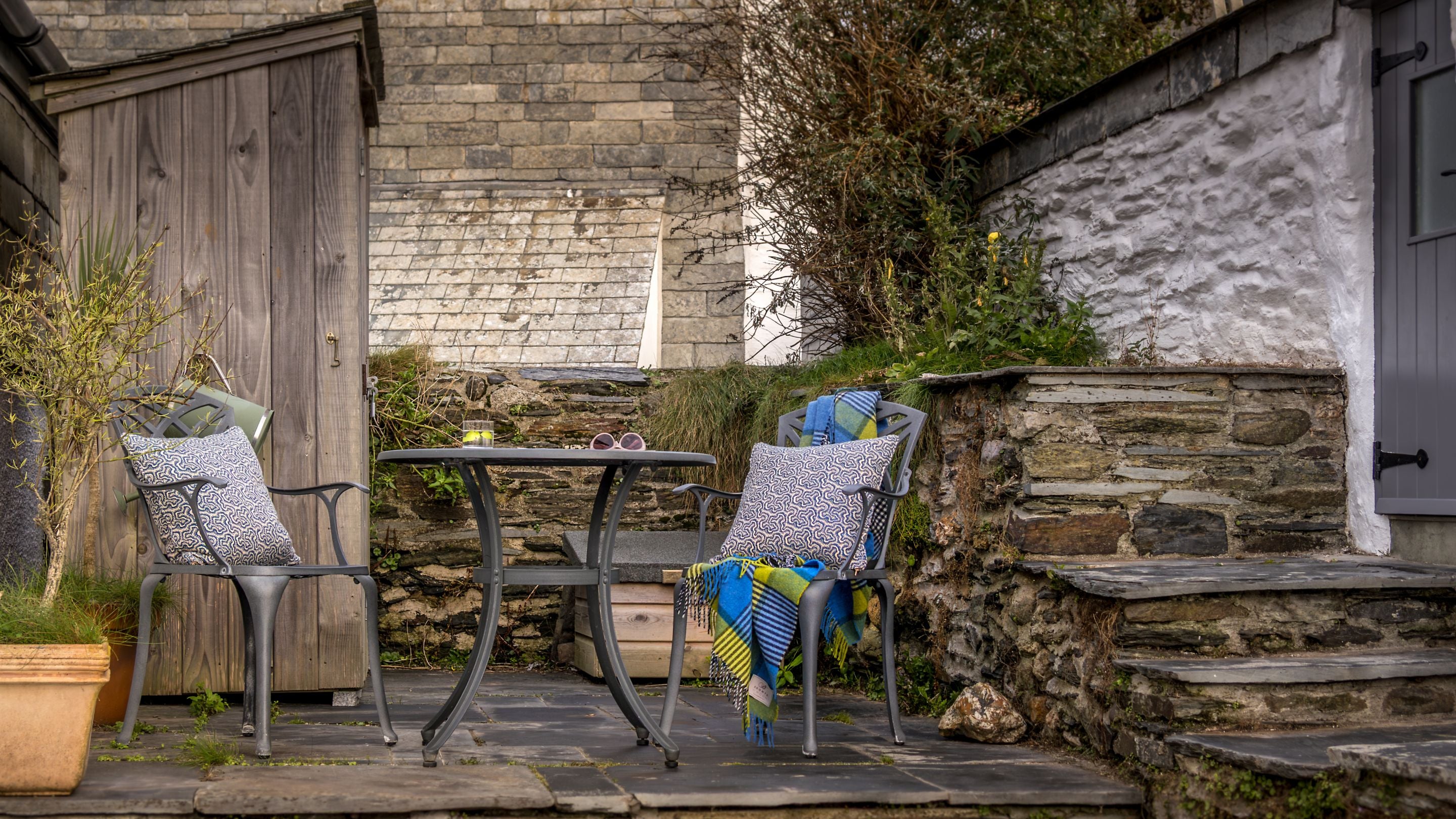 The garden terrace at The Birdcage, with outdoor dining furniture, Cornwall