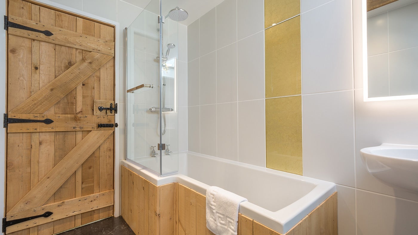 The double bedroom's en-suite bathroom, with shower over bath, at Bosigran Cottage, Cornwall