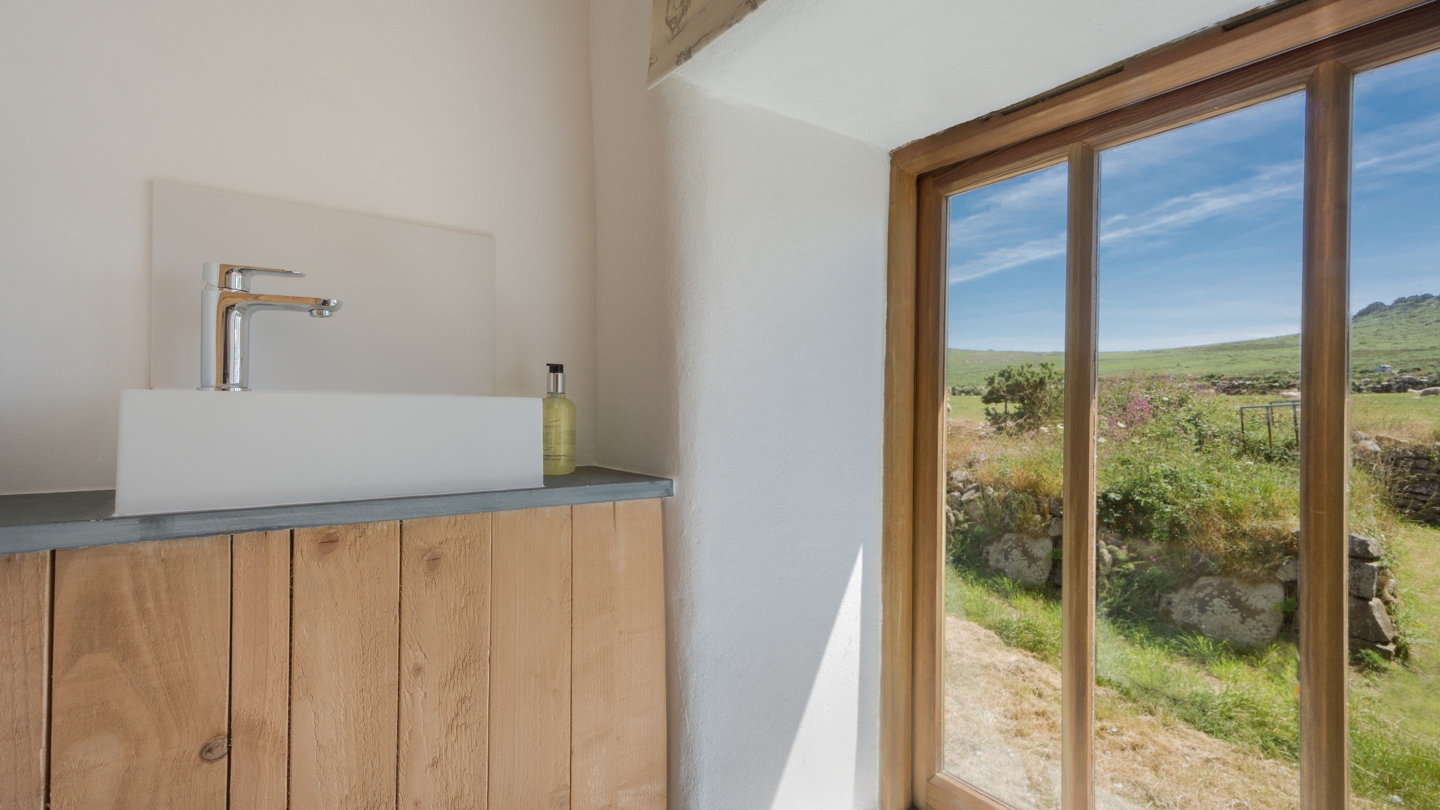 The window in the first-floor toilet at Bosigran Cottage with views over fields toward Carn Galver, Cornwall
