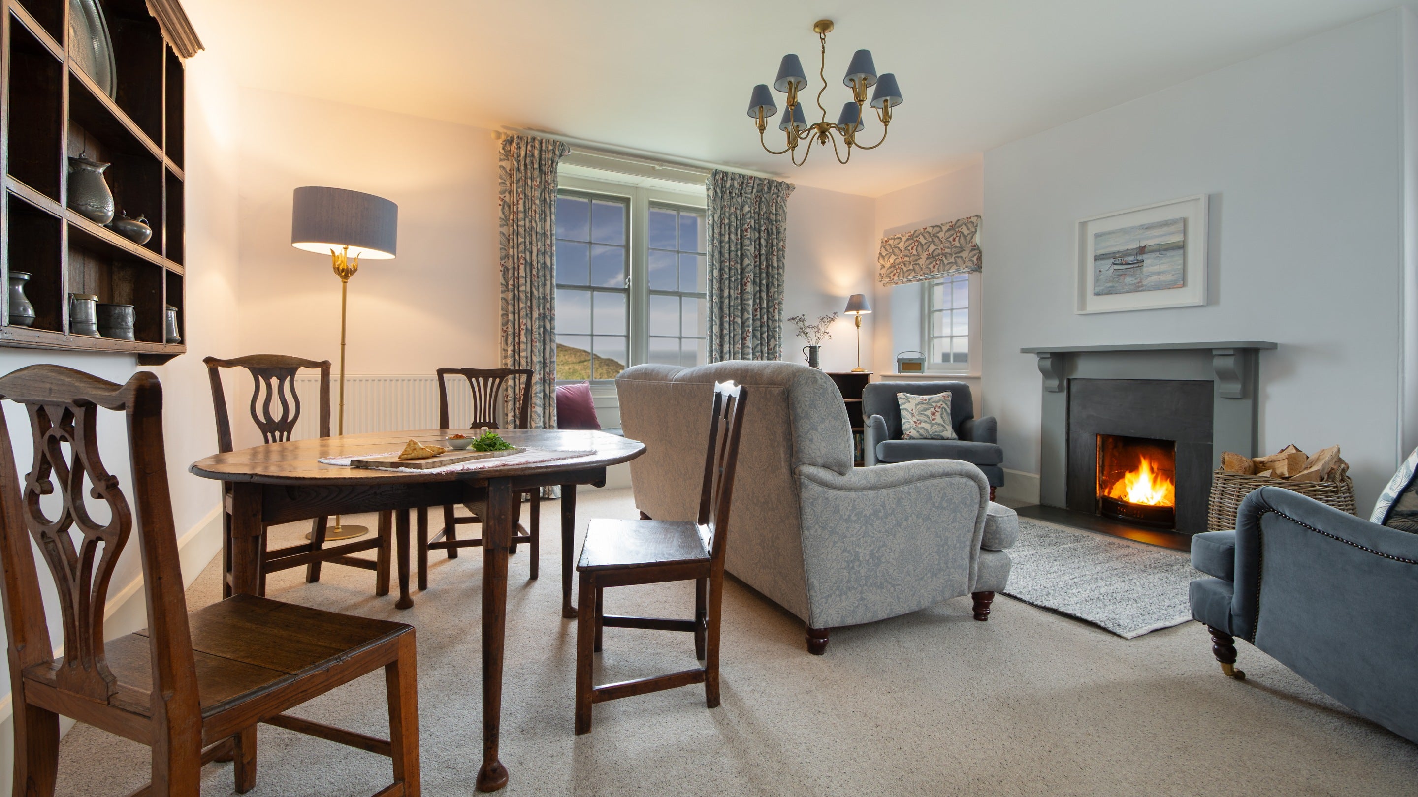 The open-plan sitting and dining room with open fire at Carnweather, Cornwall