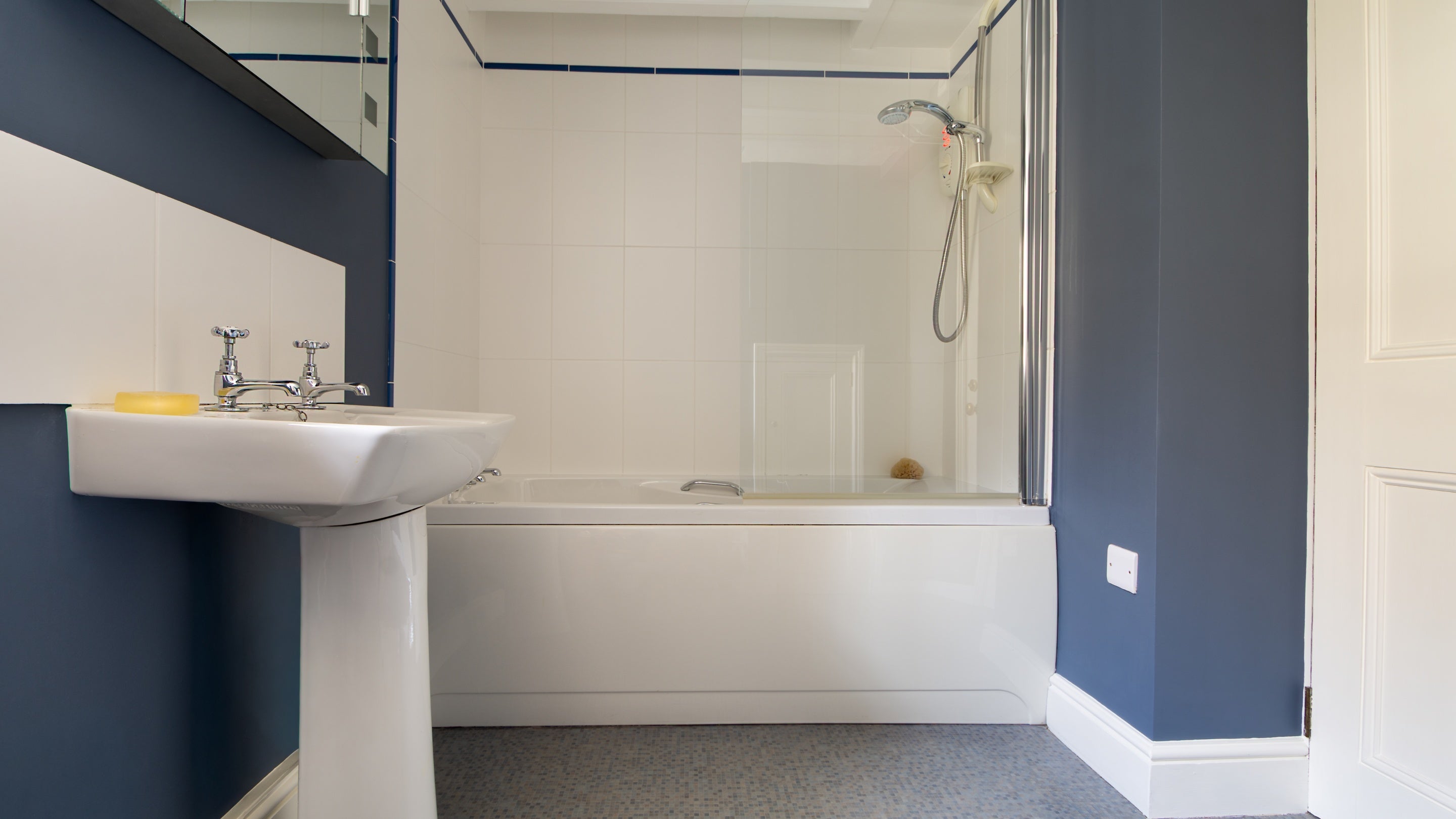 The bathroom on the ground floor of Chenhalls Barn, with shower over bath, Cornwall