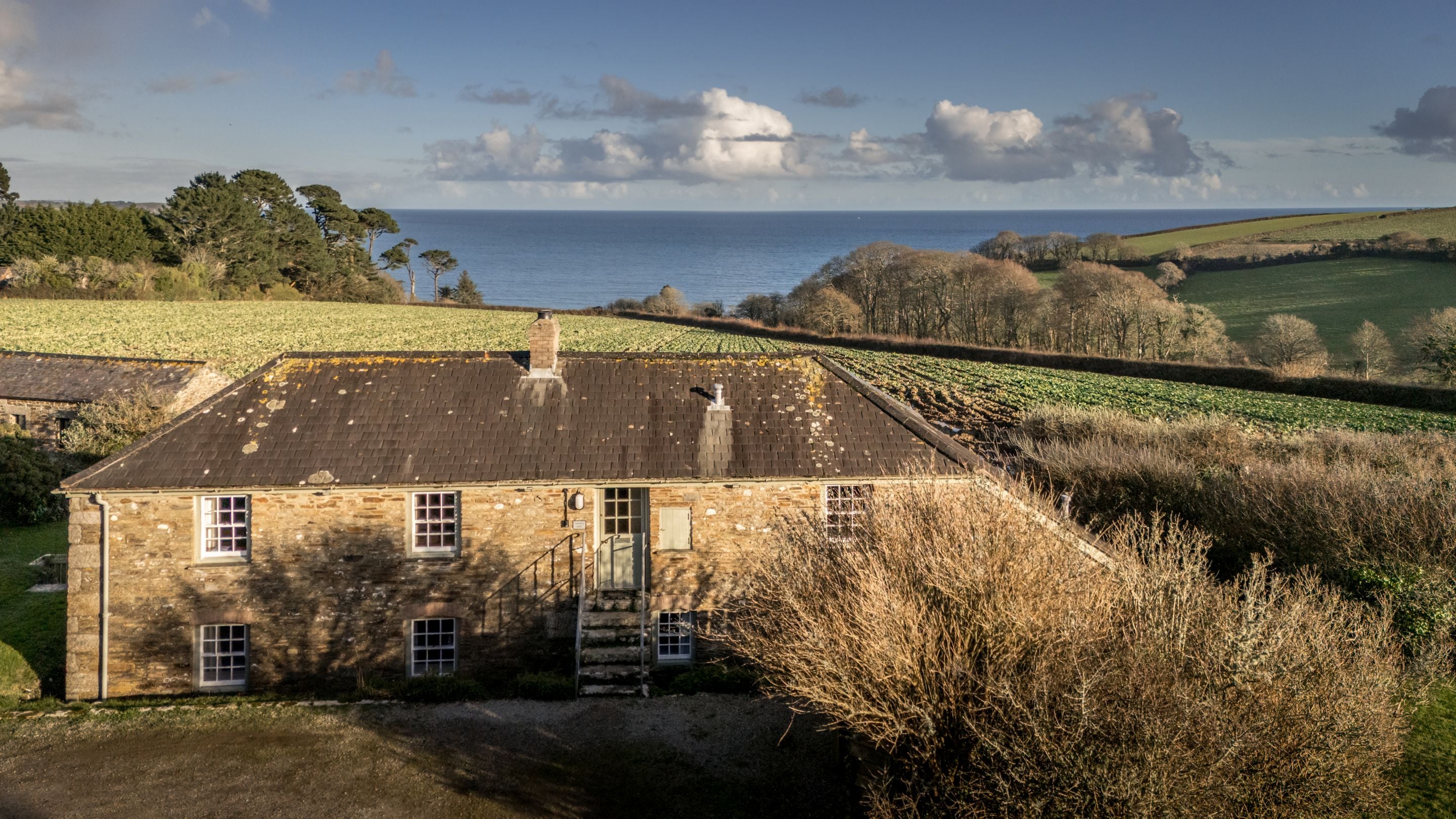 An aerial view of Chenhalls Barn with the sea in the distance, Cornwall