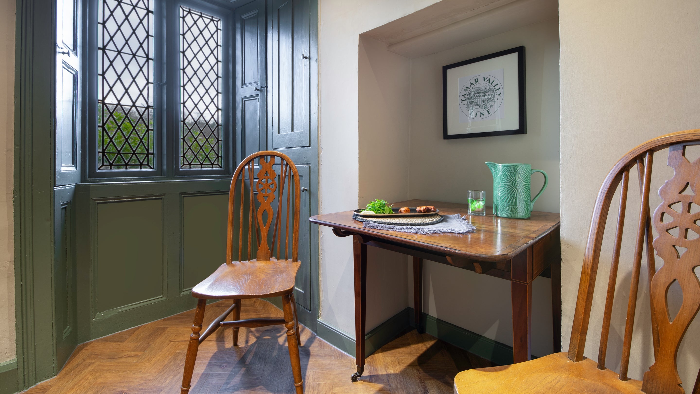 The kitchen with a table for two at Cotehele Quay Lodge Cottage, Cornwall