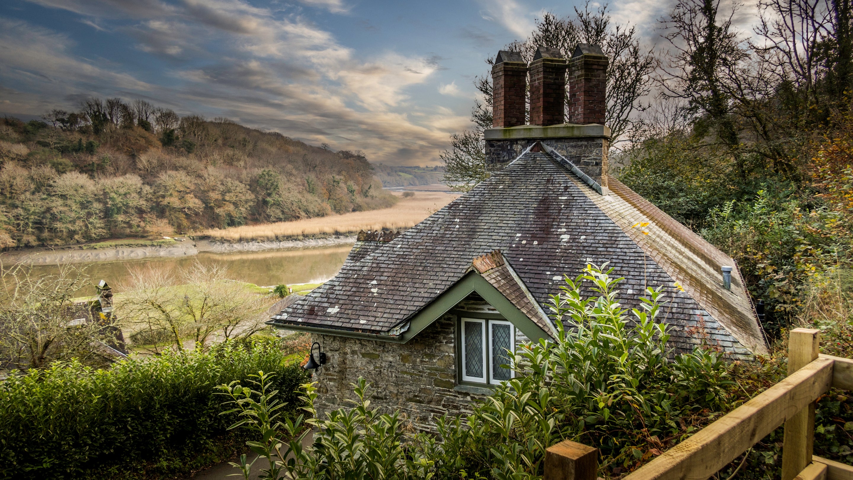The exterior of Cotehele Quay Lodge Cottage and the view down to the Tamar River, Cornwall