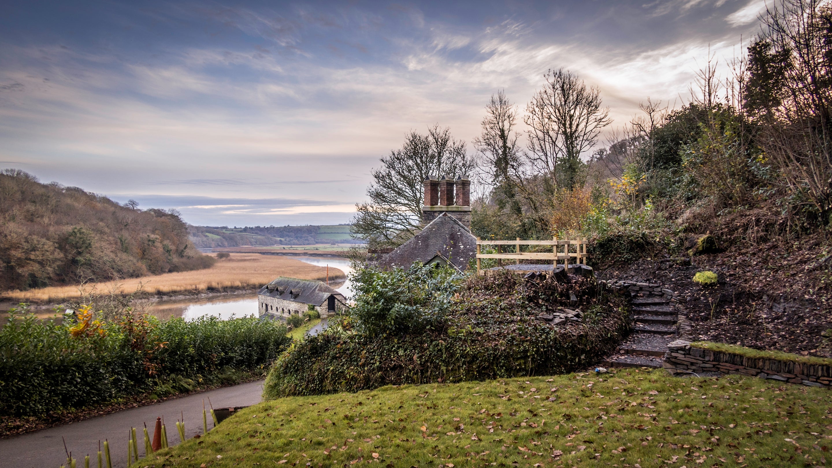 The exterior of Cotehele Quay Lodge Cottage and the view down to the Tamar River, Cornwall