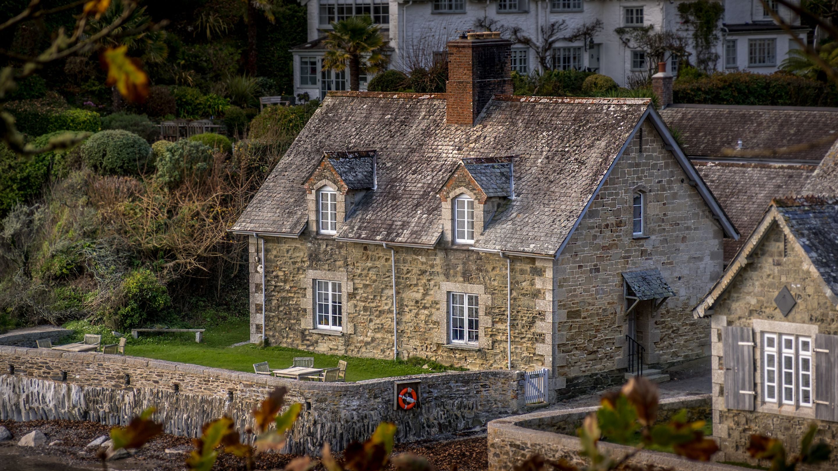 Durgan Quay Cottage (on the left) and  Durgan Beach Cottage (on the right), viewed through trees on the South West Coast Path, Cornwall