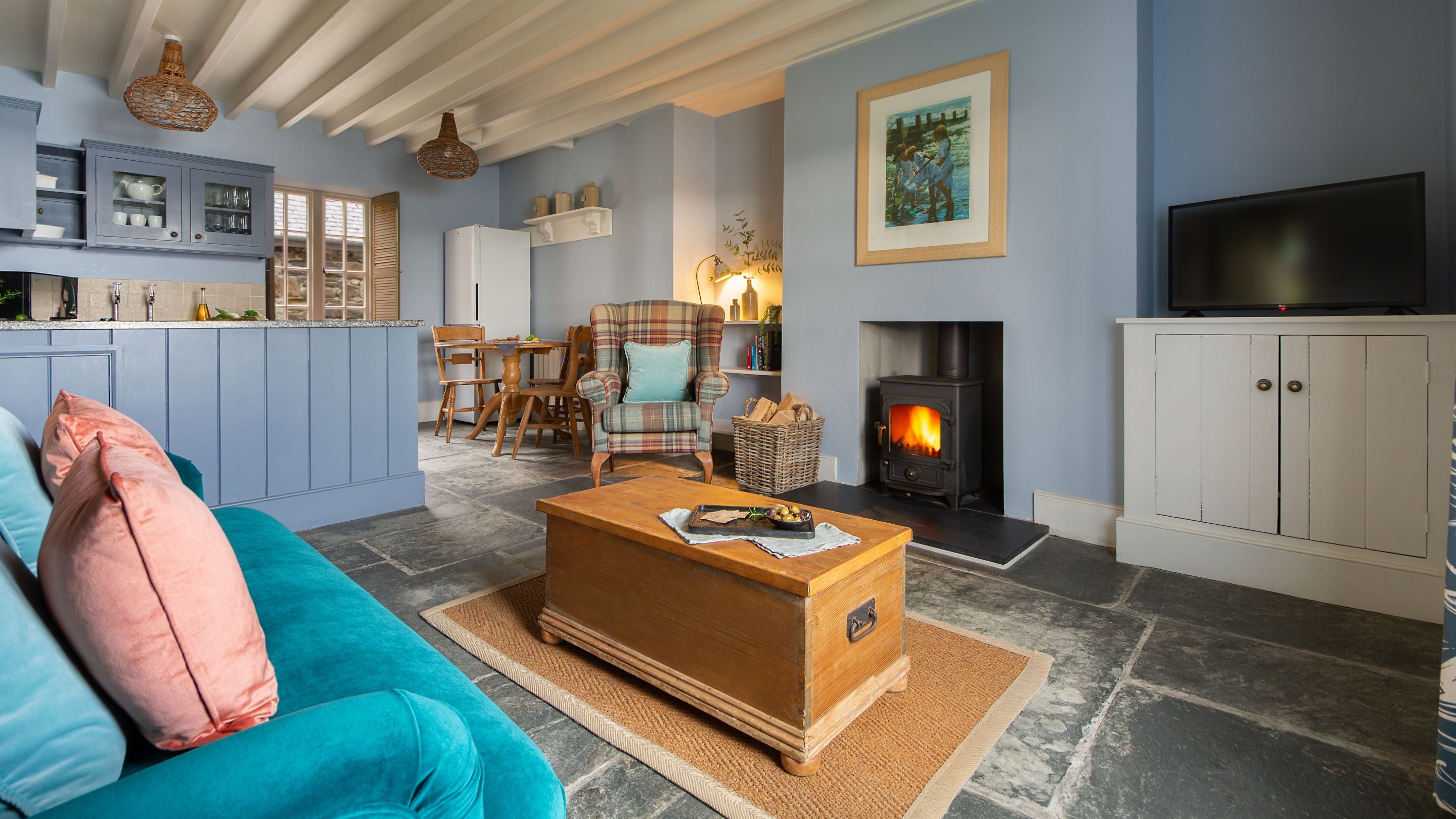 The open-plan living space with sitting area, kitchen and table for three at Durgan Quay Cottage, Cornwall