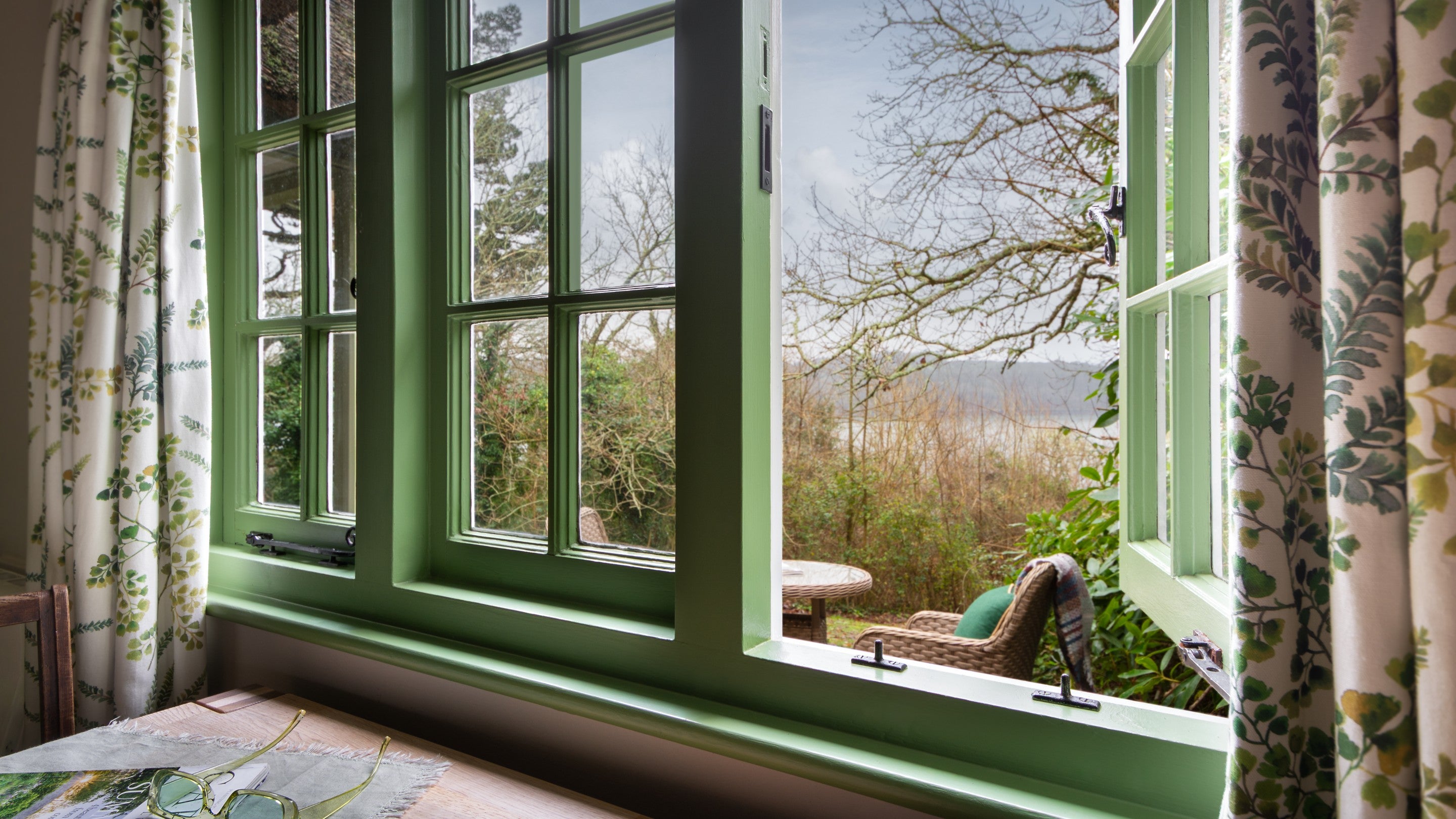The window in the living space at Durgan Wood Cottage, in winter, with views toward the Helford River, Cornwall