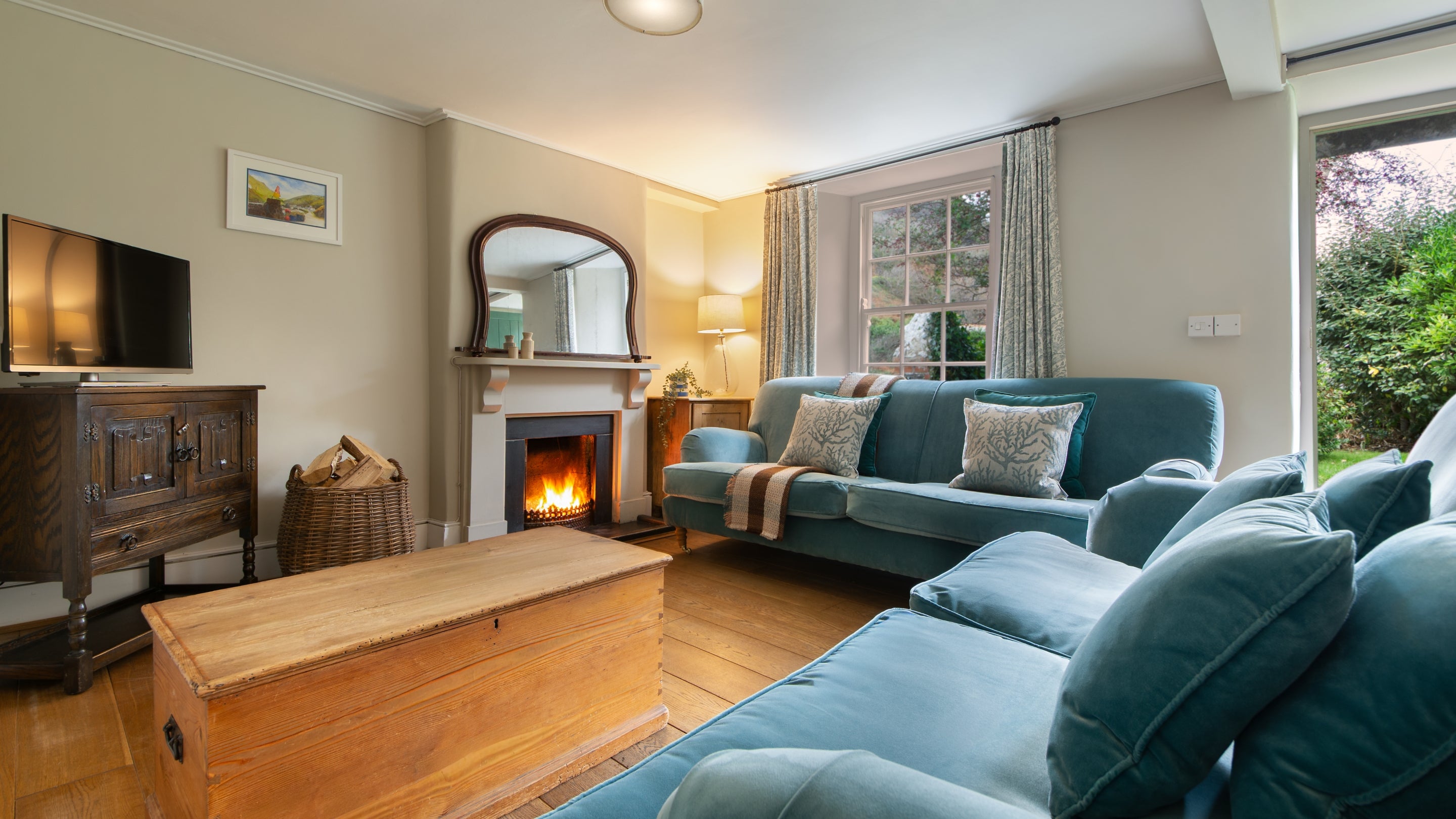 The sitting room area with open fire in the open-plan sitting and dining room at Harbour View, Cornwall