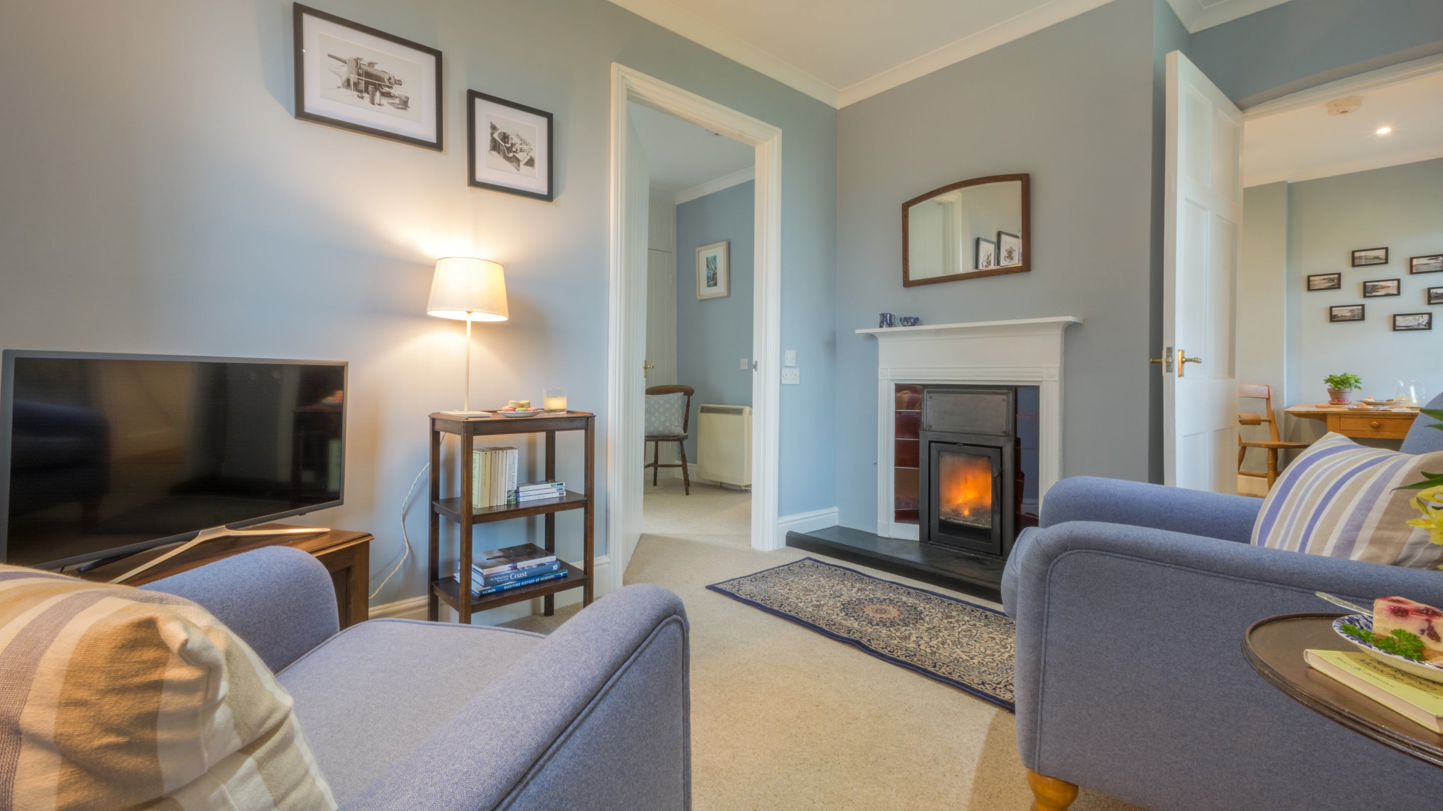 The sitting room with armchairs and multi-fuel stove at The Lieutenant's Quarter, Cornwall