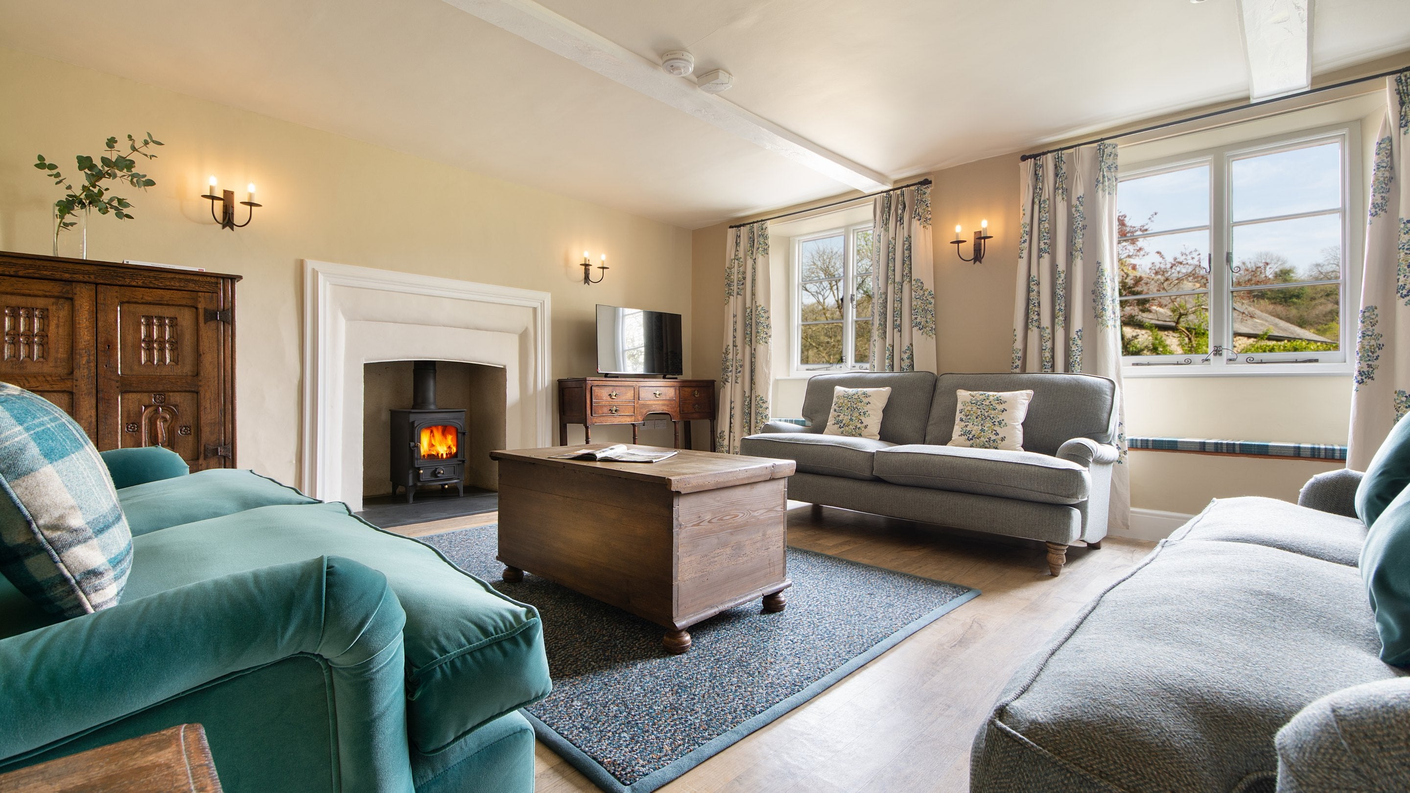 The sitting room with woodburner, sofas and television at Malt House, Cornwall