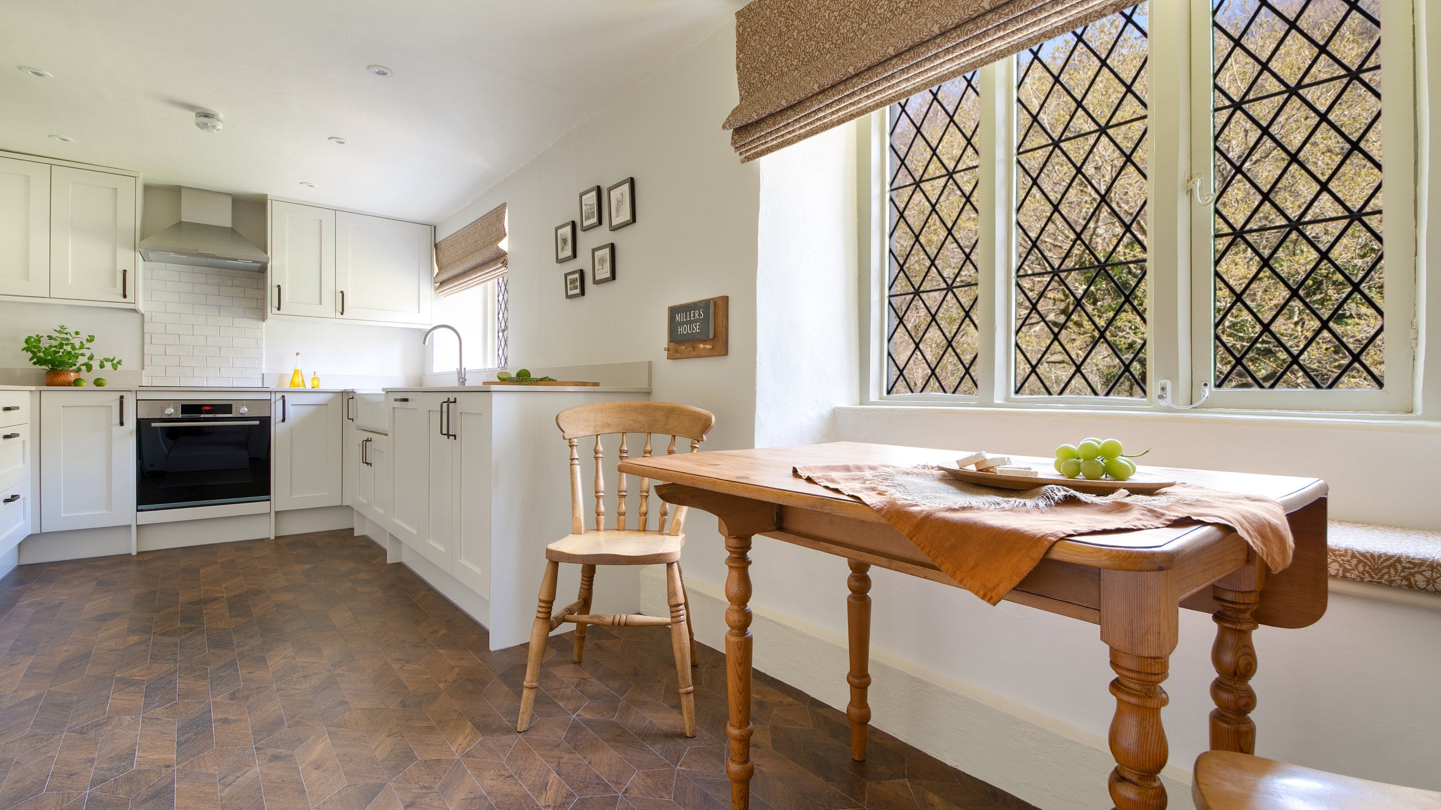The kitchen with small breakfast table and latticed windows at Miller's House, Cornwall