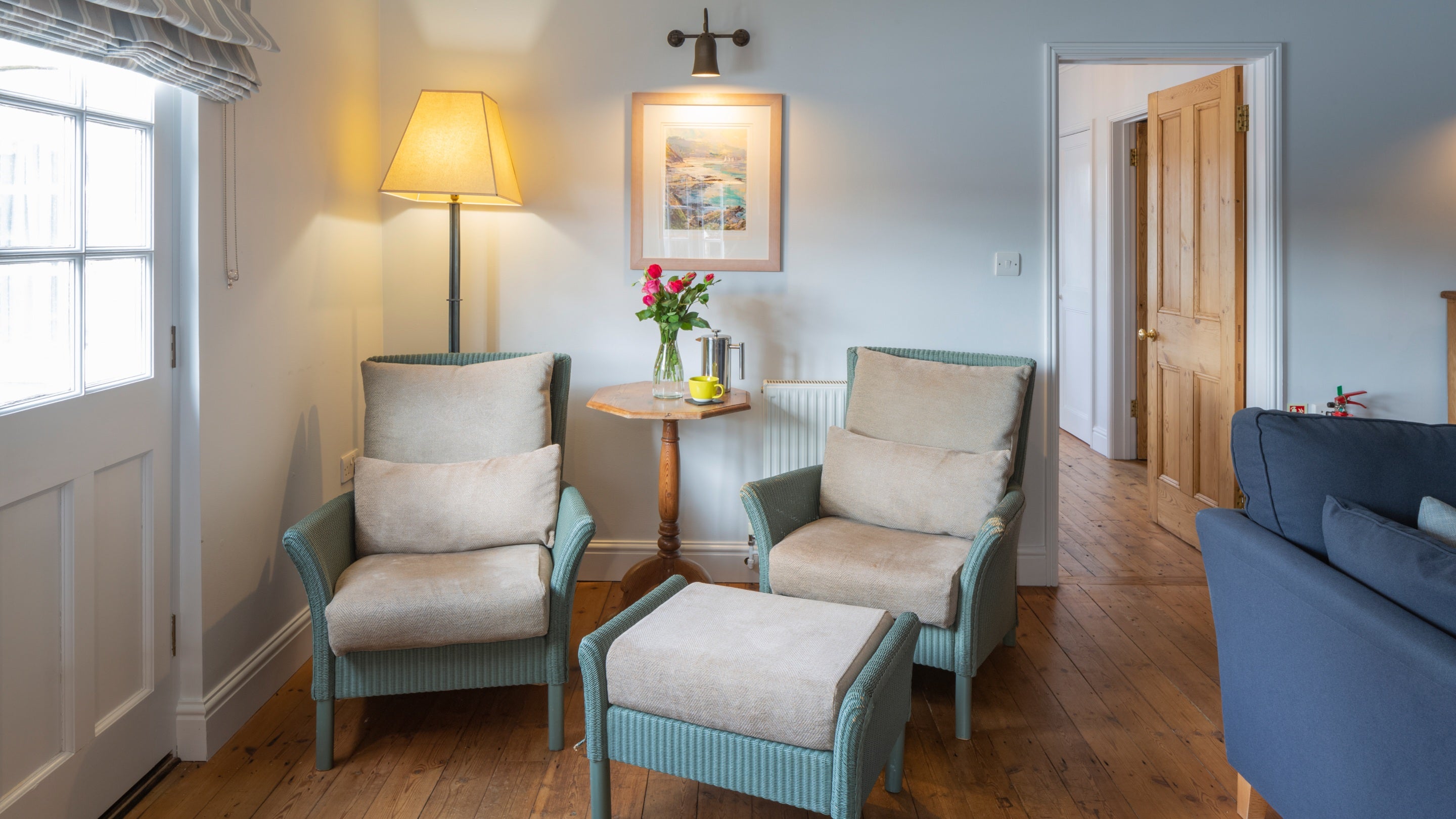Wicker armchairs in the sitting room at Powders, Cornwall
