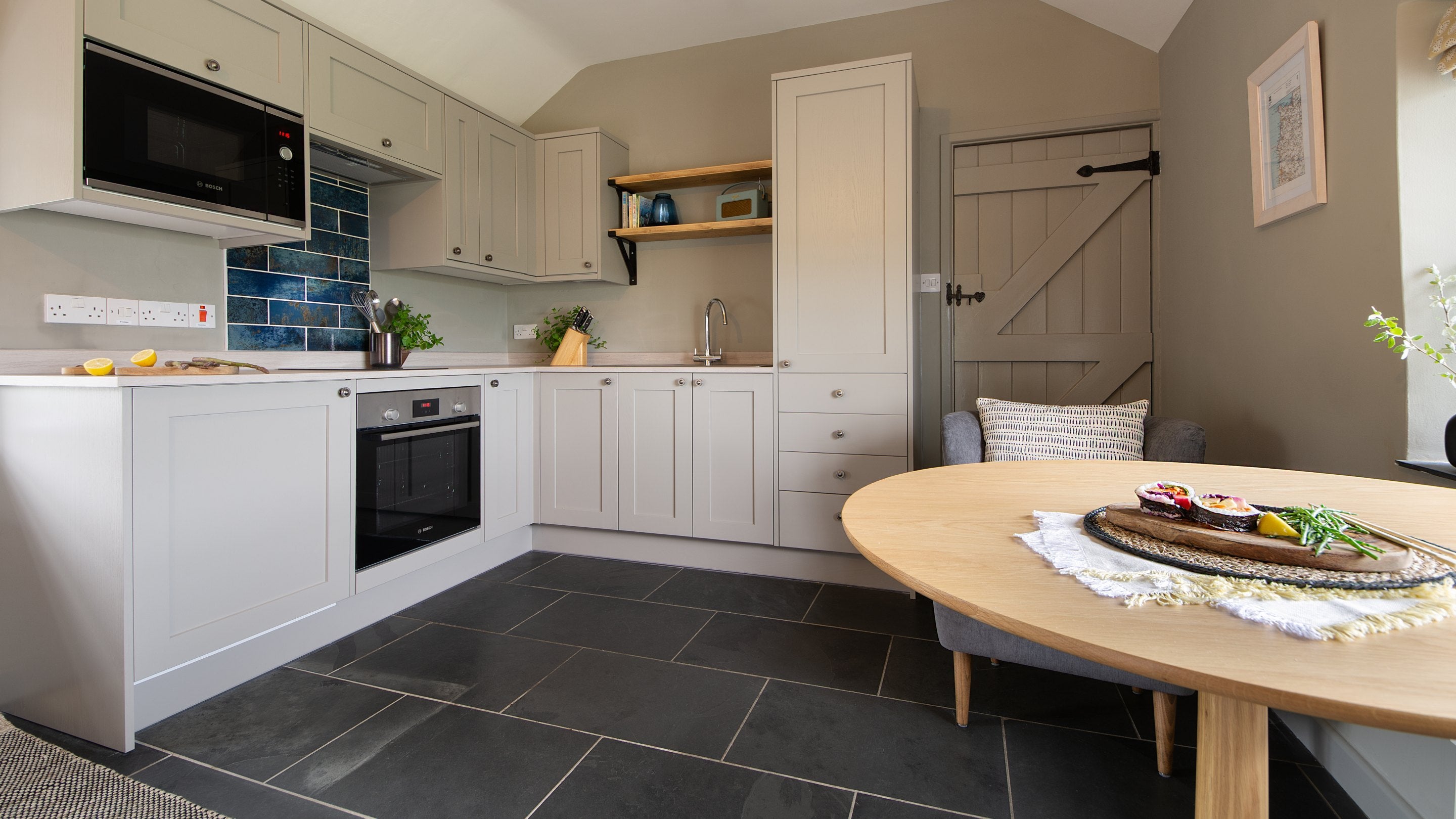 The kitchen area and table for two in the open-plan living space at Skipper's Cabin, Cornwall