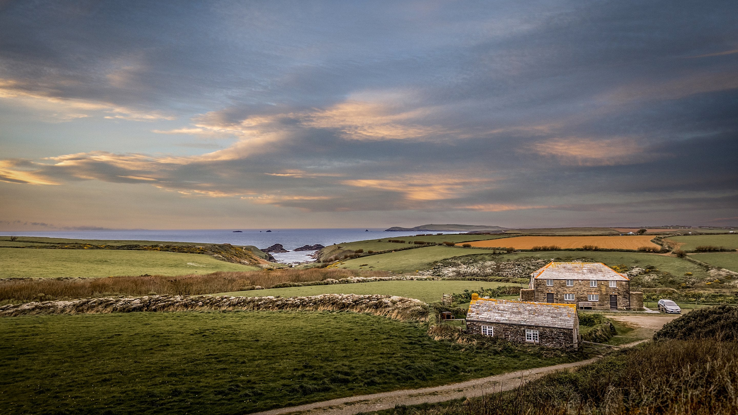 An aerial view over Skipper's Cabin's roof towards Porth Mear Barn (sleeps six), and the surrounding coastal area, Cornwall