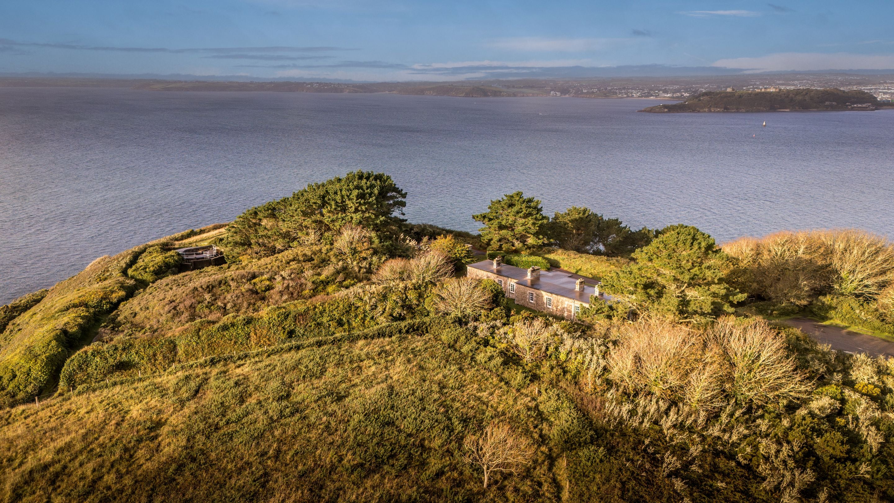 An aerial view of the back of the holiday cottages at St Anthony Head, and the surrounding headland and estuary, Cornwall