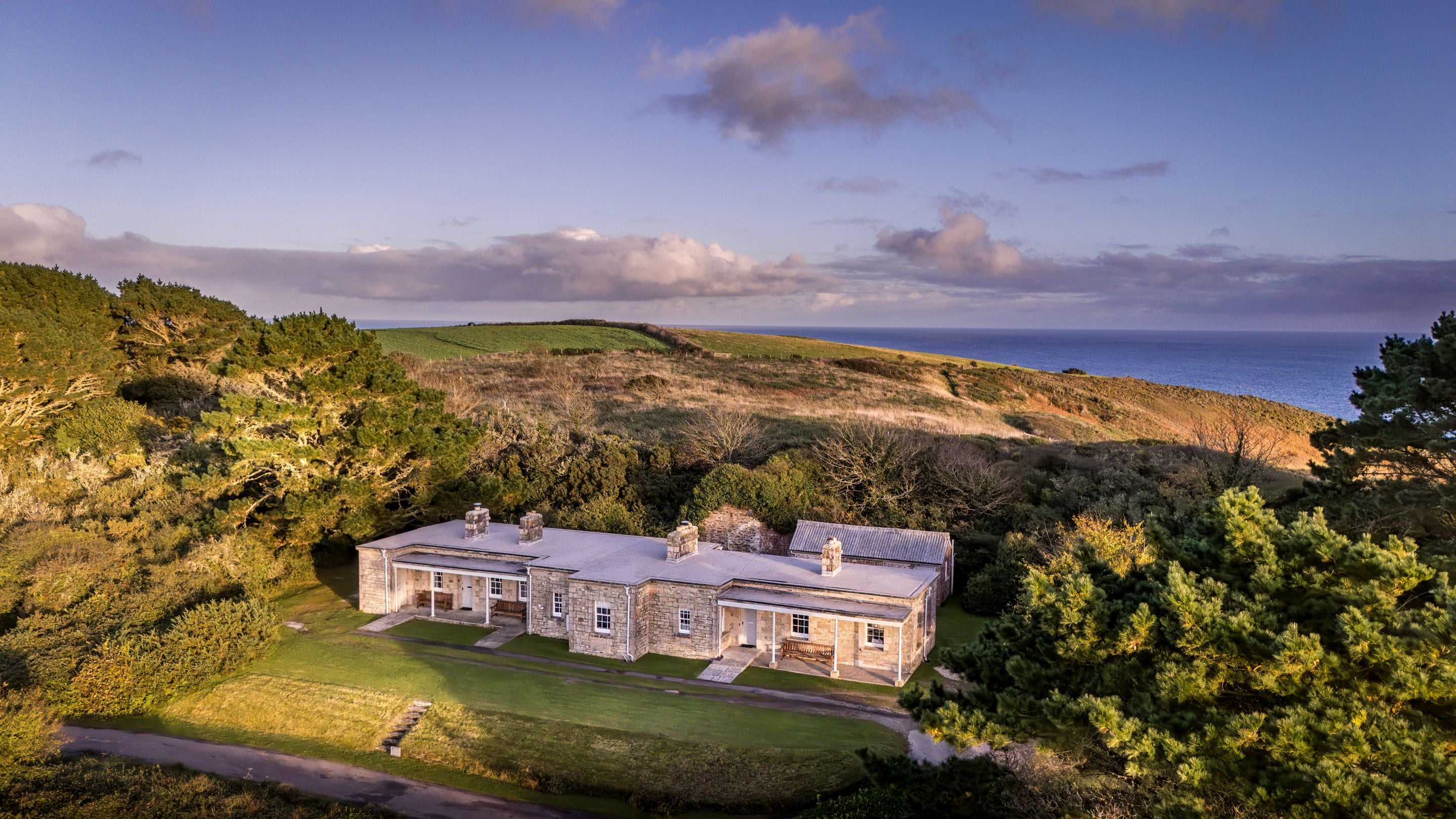 An aerial view of The Lieutenant's Quarter, The Major's Quarter and The Captain's Quarter, and the headland and sea beyond, Cornwall