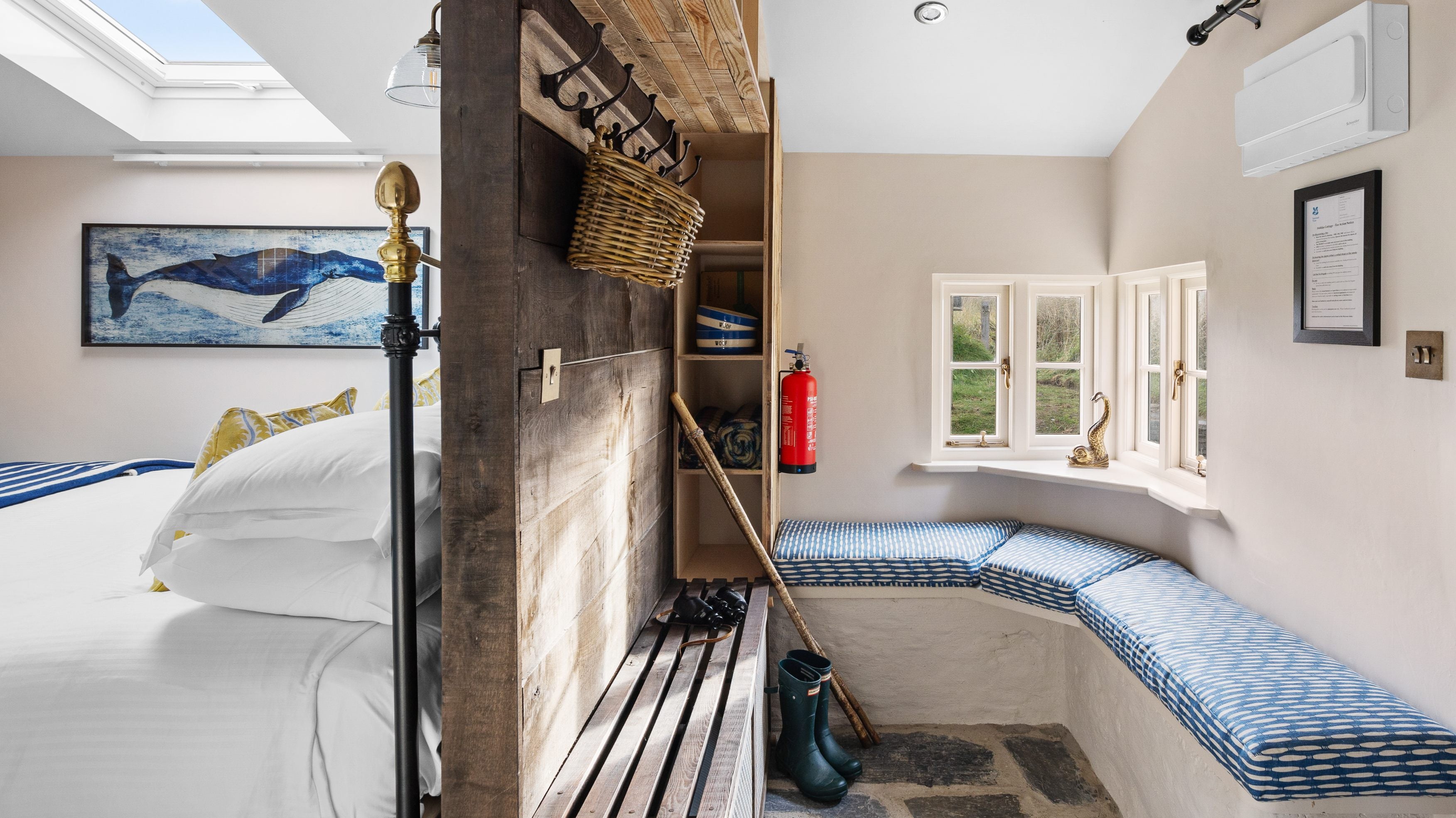 The entrance hall with benches, storage shelves and coat hooks, leading into the bedroom at Tom Parsons' Hut, Cornwall