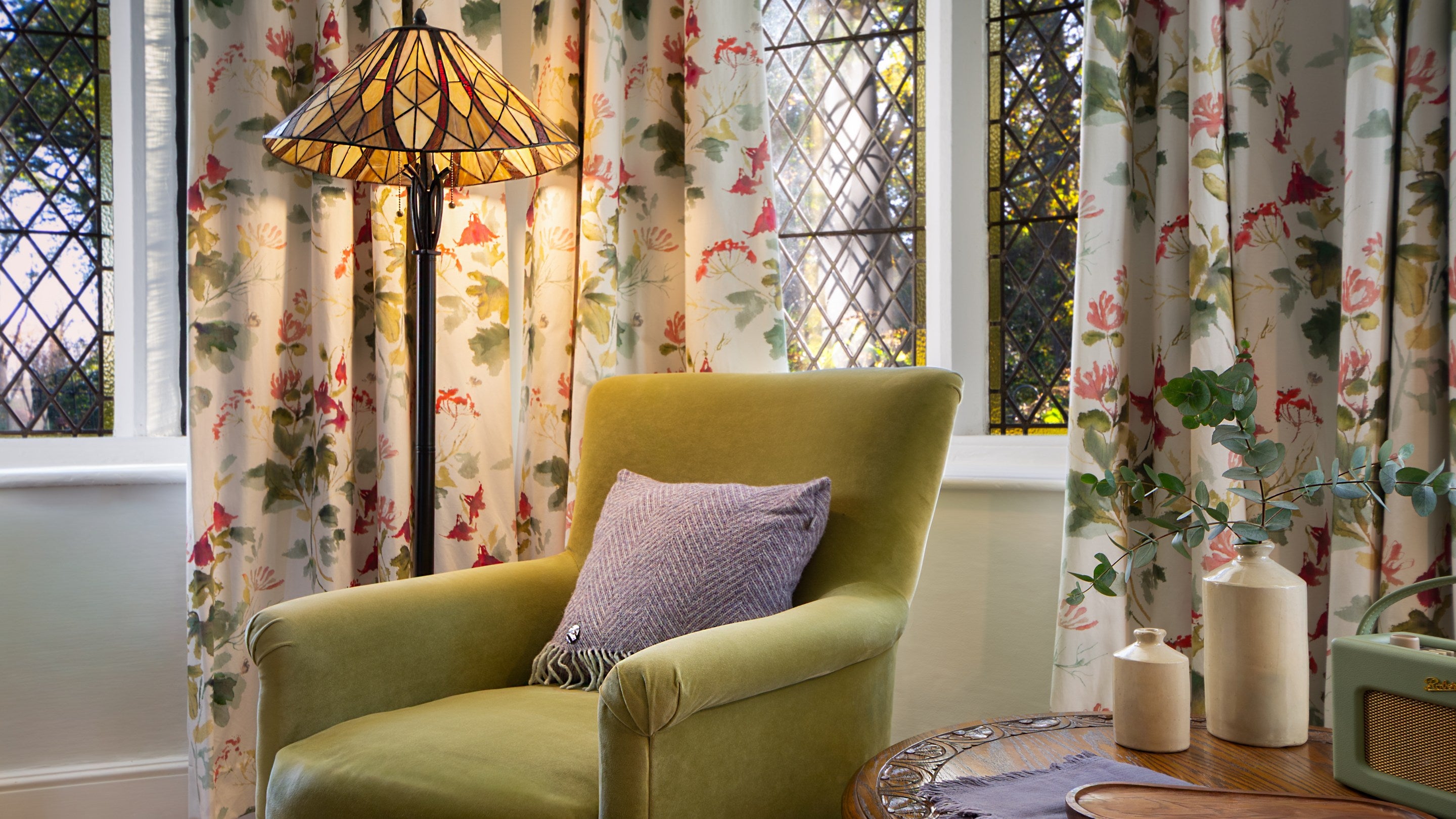 Part of the sitting room at Trelissick New Lodge, showing an armchair in front of latticed windows, Cornwall