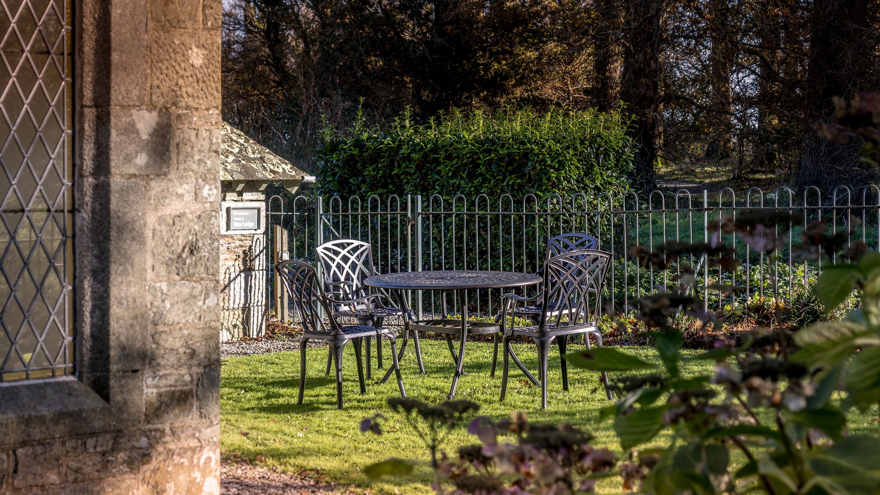 The garden at Trelissick New Lodge, with lawn and metal dining furniture, Cornwall