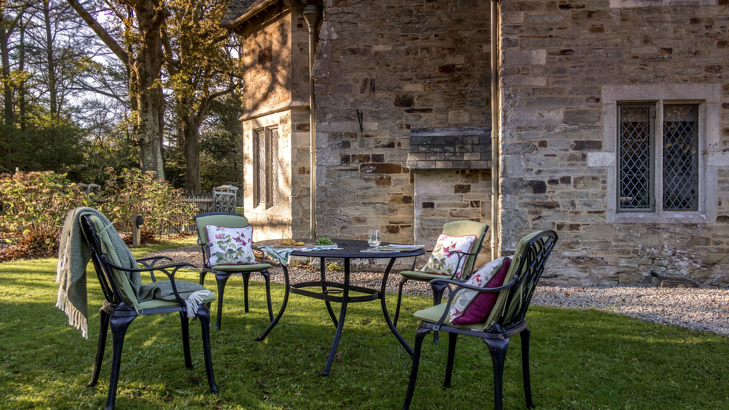 The garden with lawn and outdoor dining furniture at Trelissick New Lodge, Cornwall