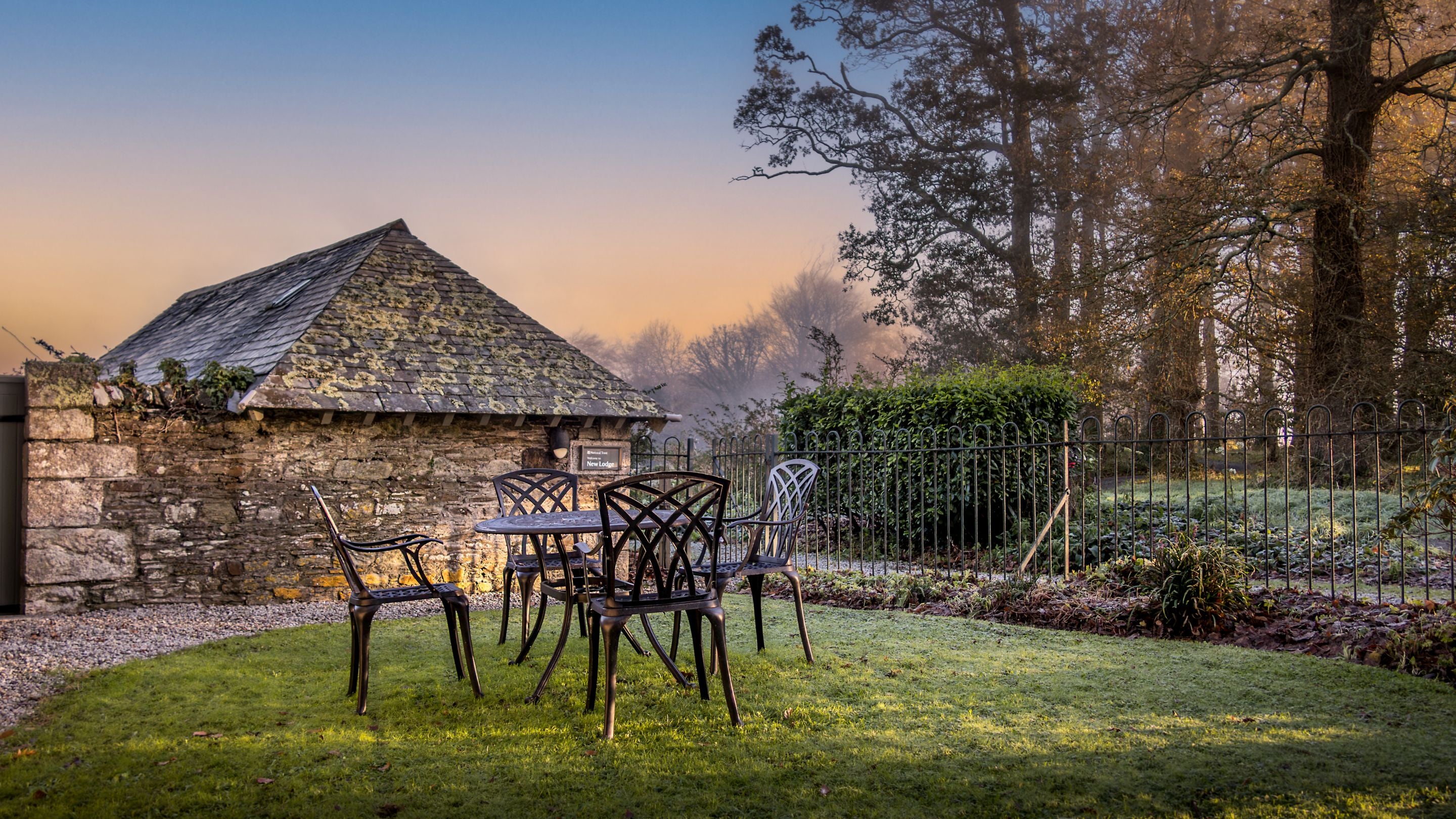 The garden at Trelissick New Lodge, with lawn and dining furniture, Cornwall