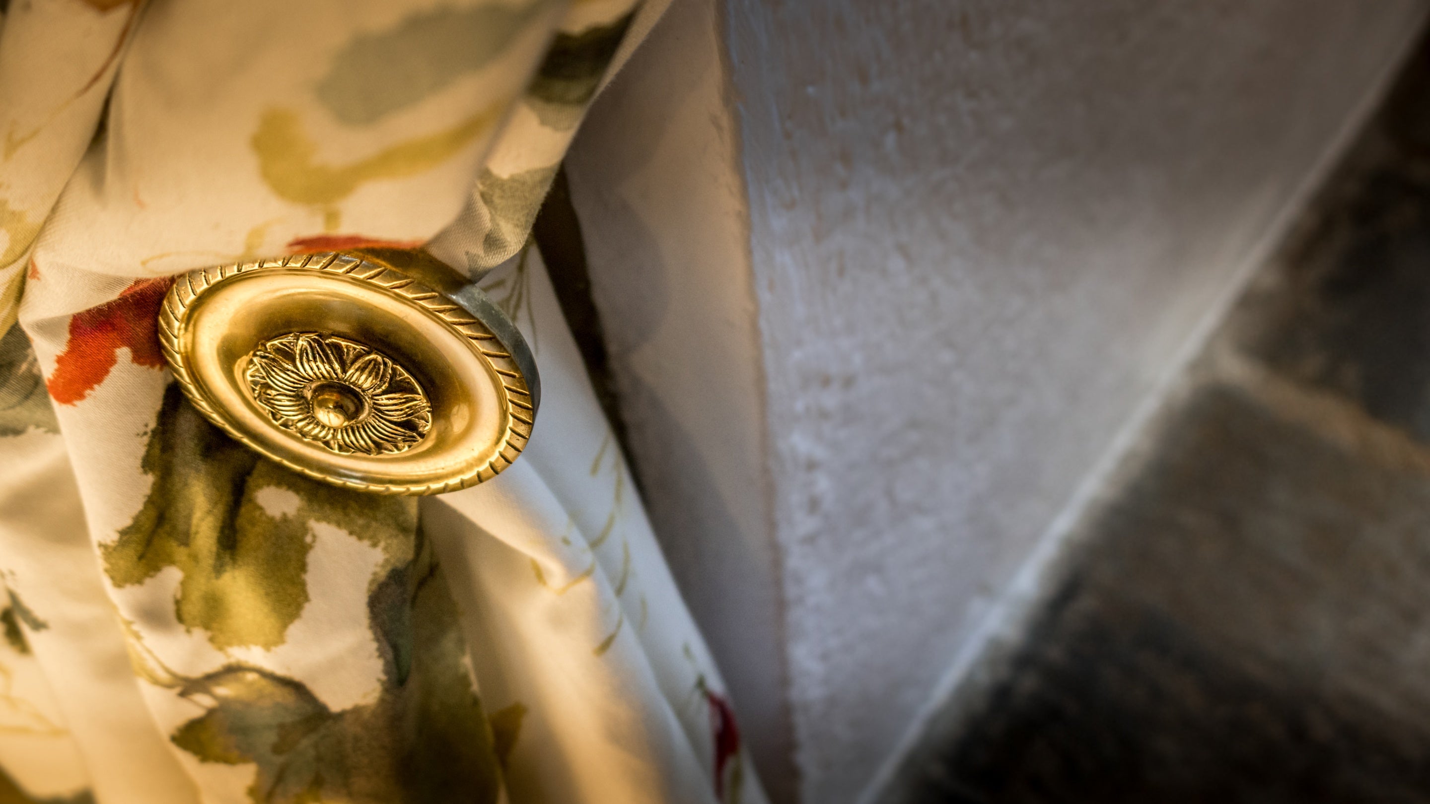 A metal curtain hook in the bedroom with flower details at Trelissick Water Tower, Cornwall