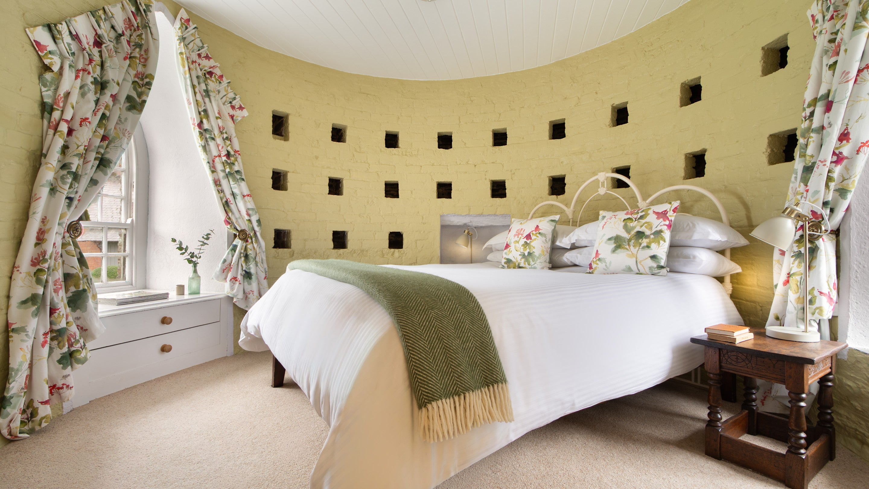 The double bedroom at Trelissick Water Tower, a circular room with two arched windows, Cornwall