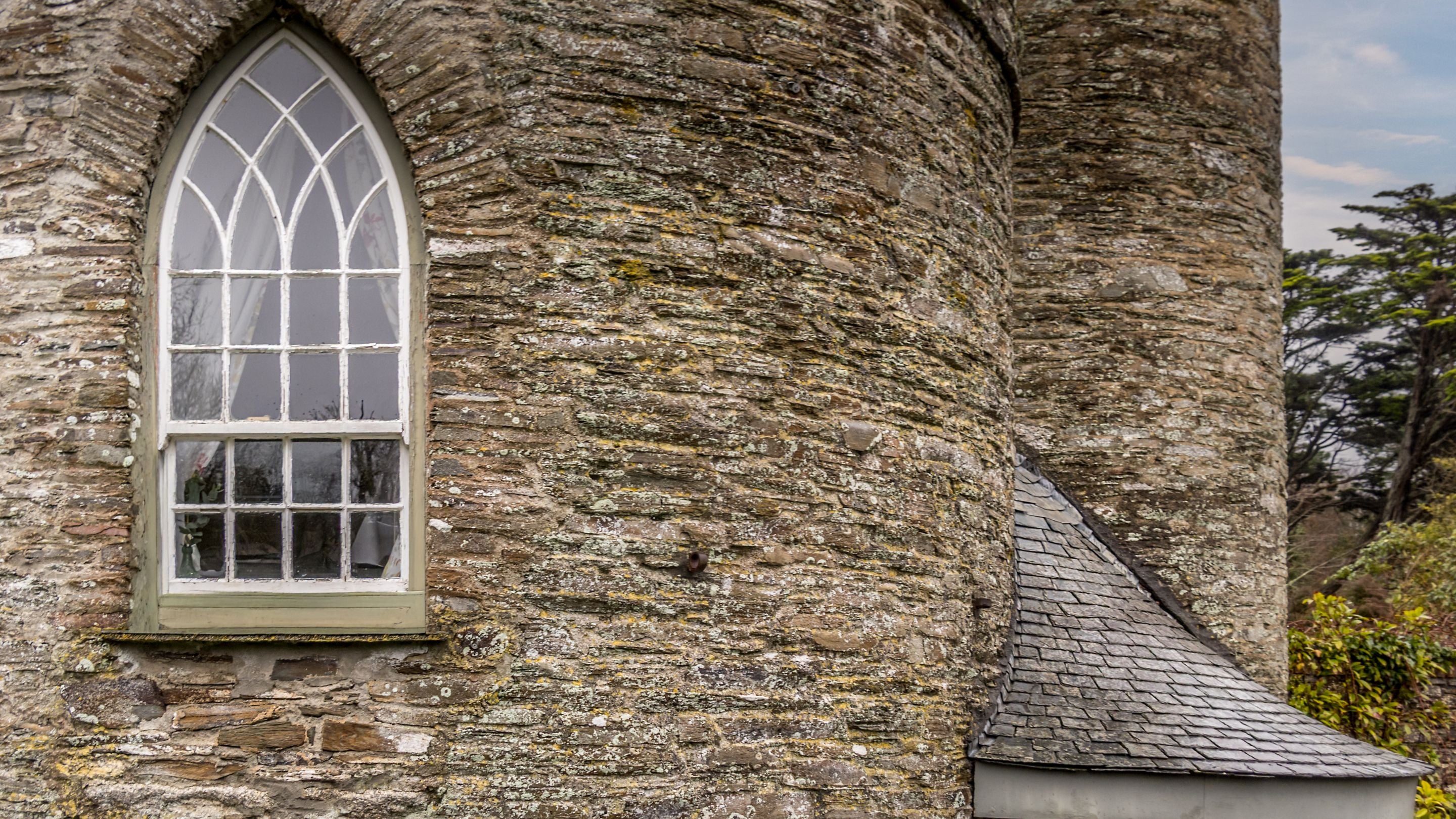 An exterior view of one of the bedroom's arched windows, on the first floor of Trelissick Water Tower, Cornwall