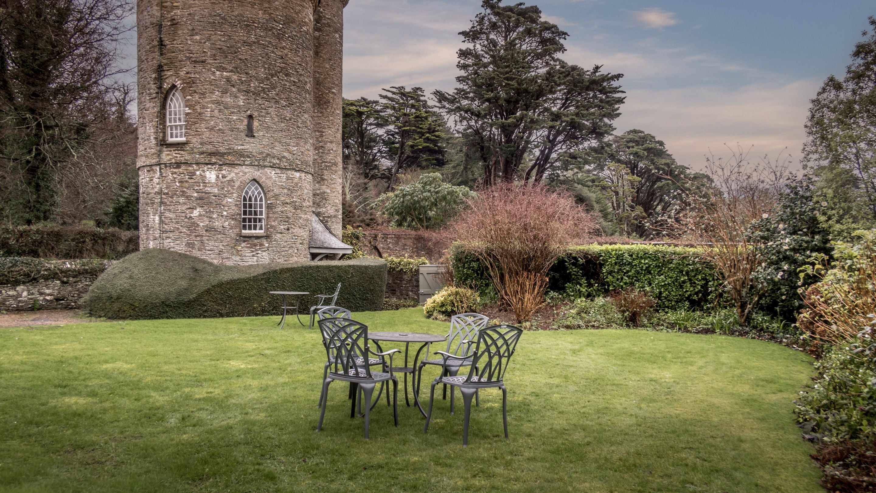 The garden at Trelissick Water Tower, which is shared with Trelissick Engine House, and has a lawn, tables and chairs, Cornwall