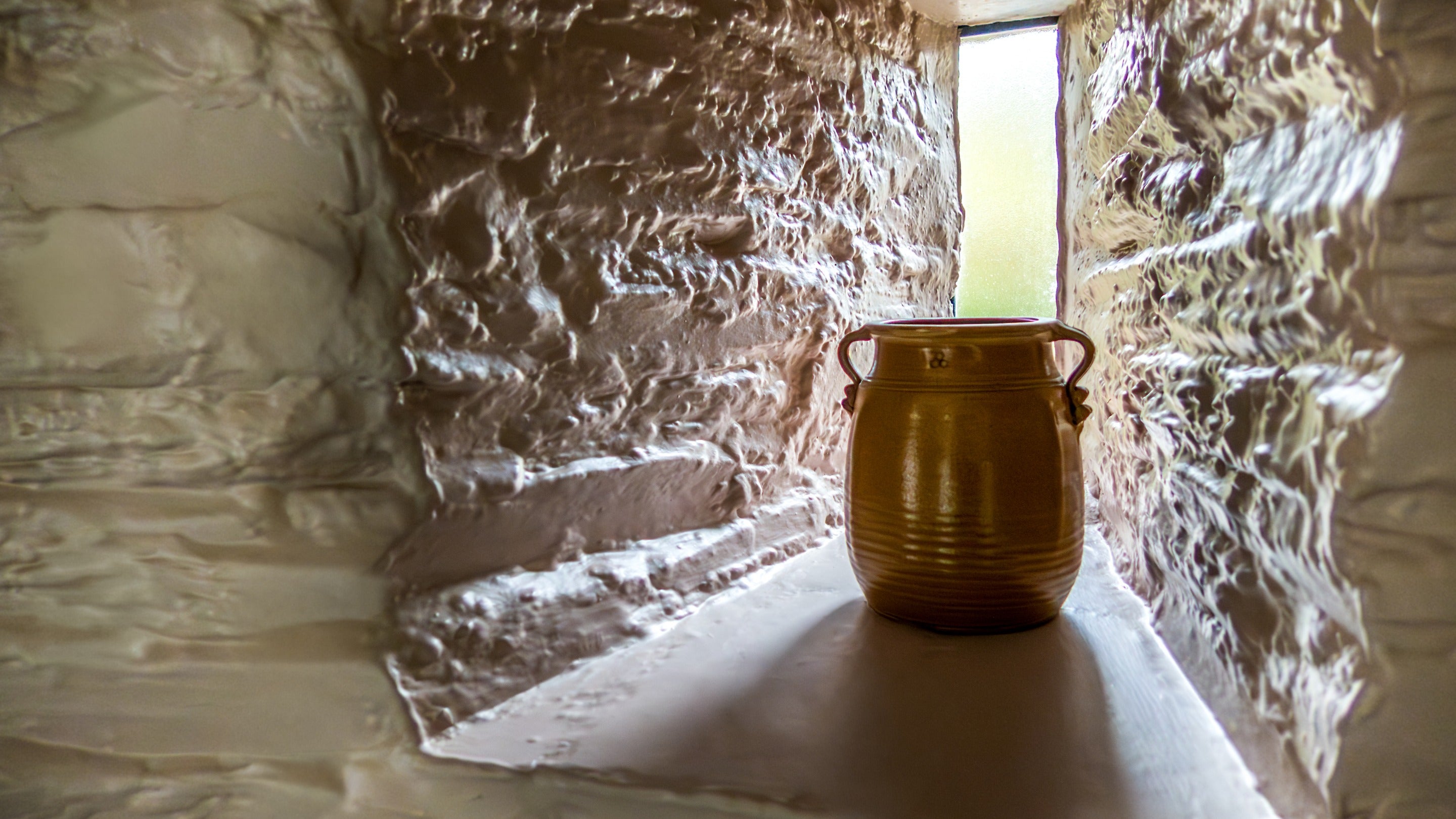 A thin window by the staircase at Trelissick Water Tower, showing the deep walls, Cornwall