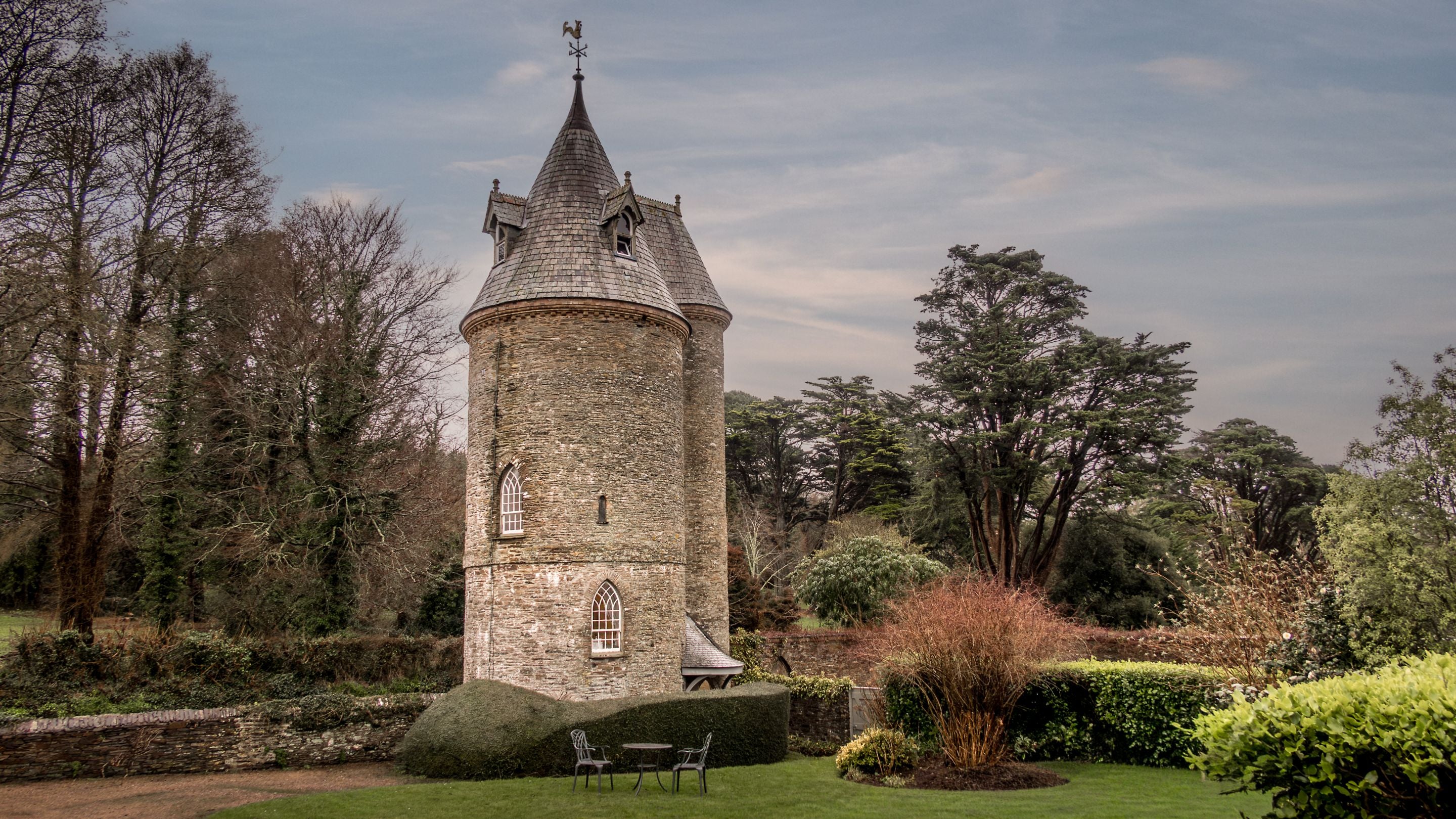 An external view of Trelissick Water Tower, a circular tower with conical roof, Cornwall
