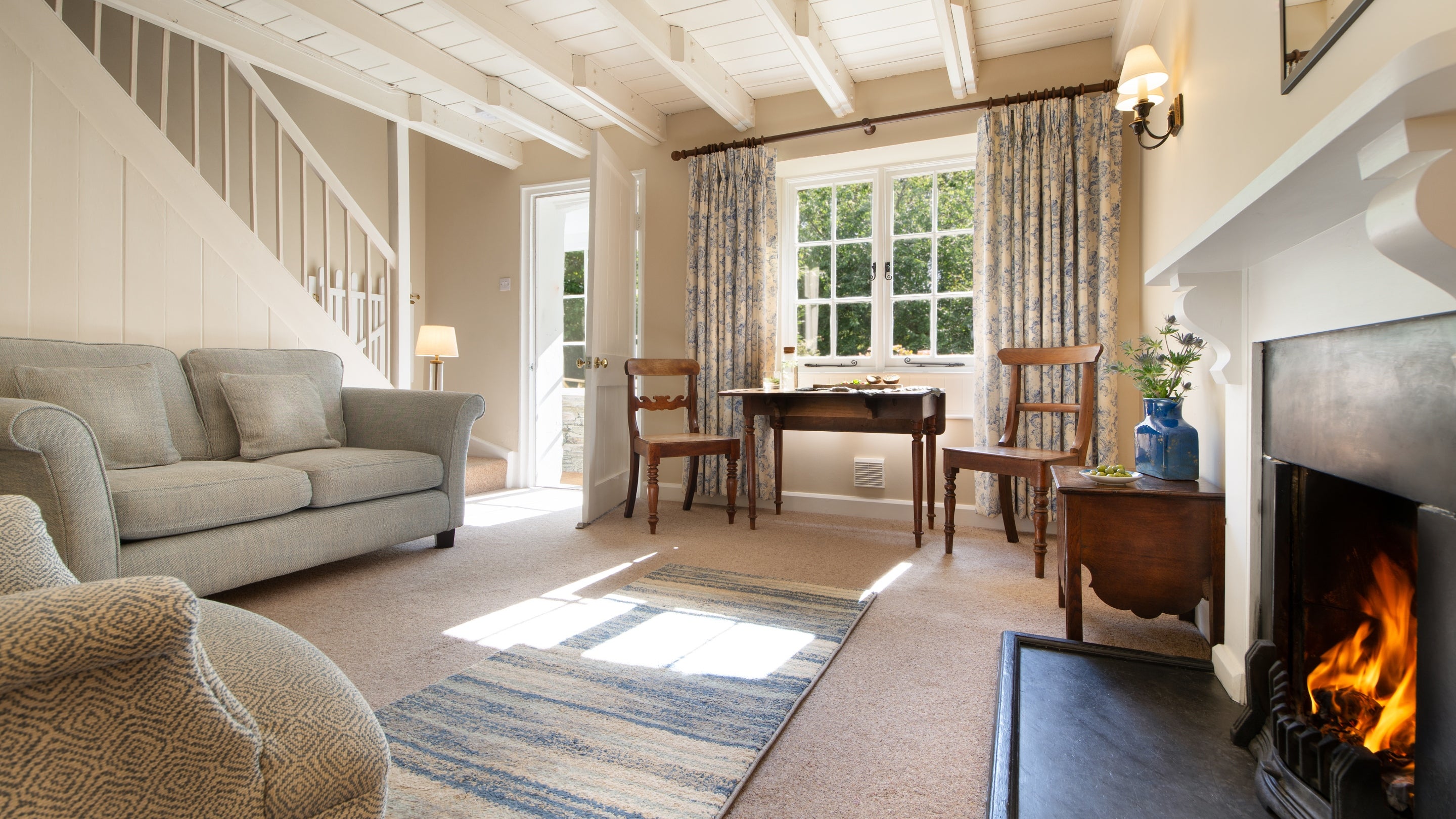 The sitting room with table for two at Triggabrowne Cottage, before the open fire was replaced with a woodburner, Cornwall