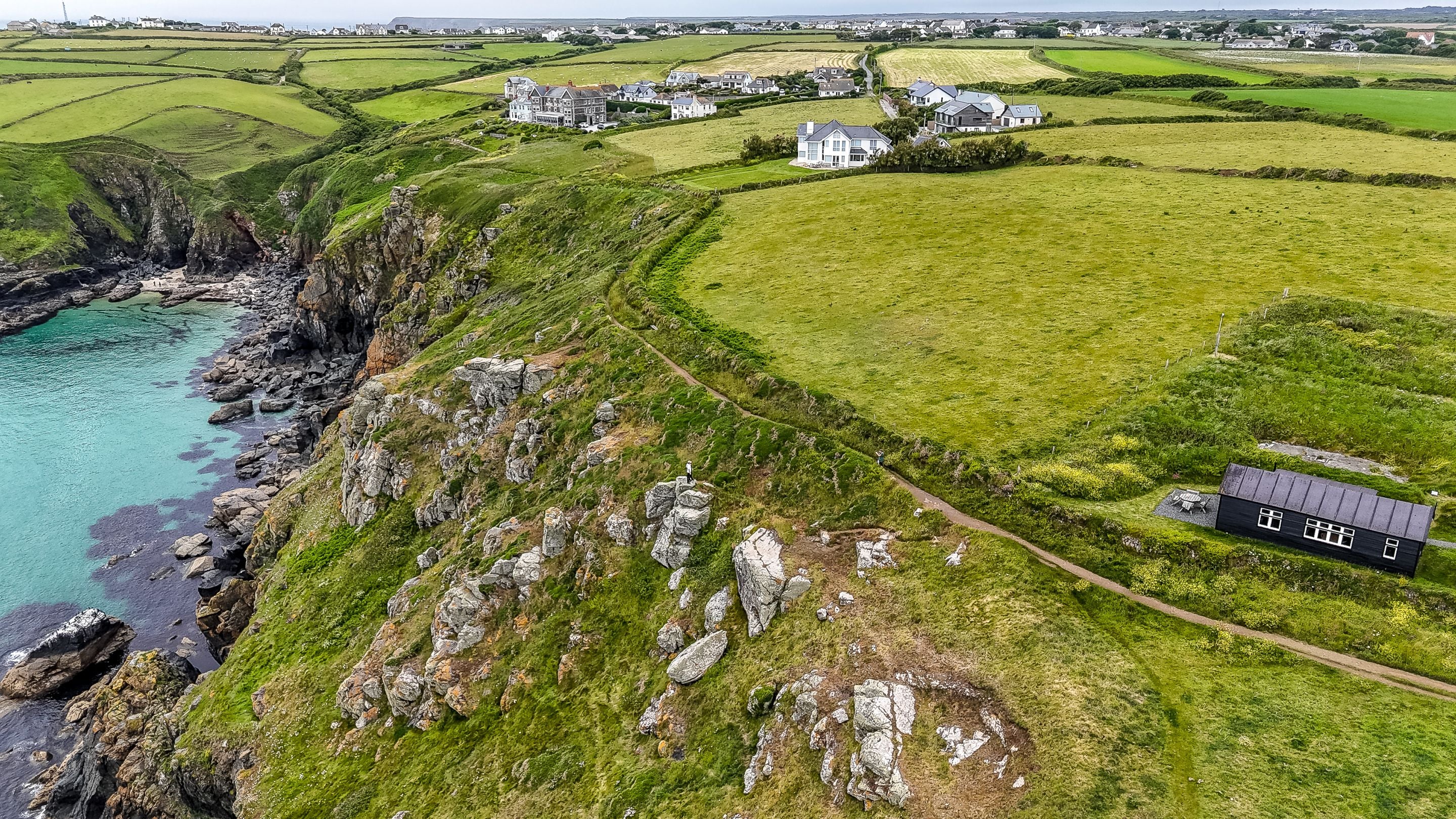 An aerial view of Wireless Cottage, next to coastal cliffs and the South West Coast Path, Cornwall