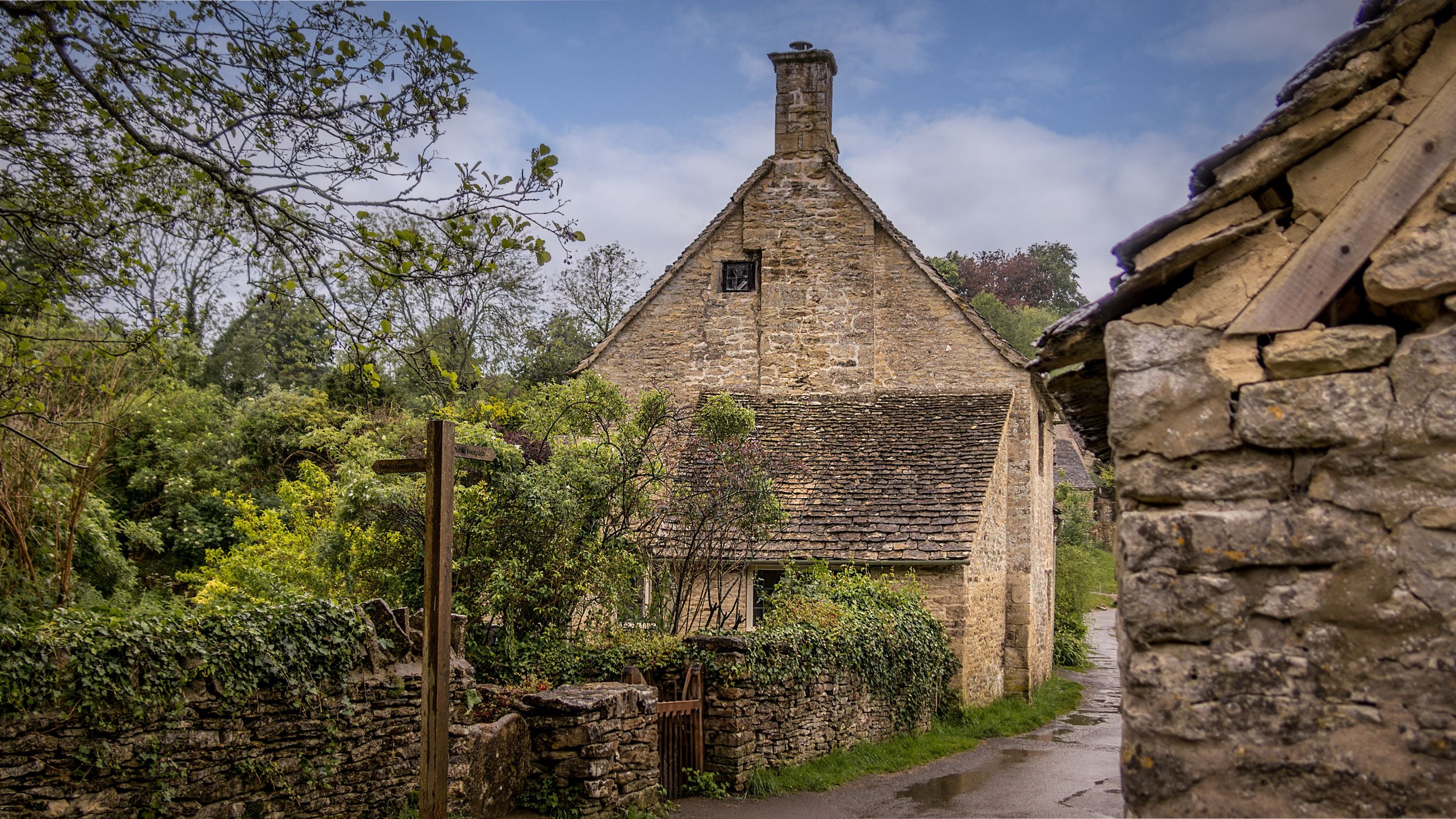 The side of 1 Arlington Row and the stone wall around the garden, Gloucestershire
