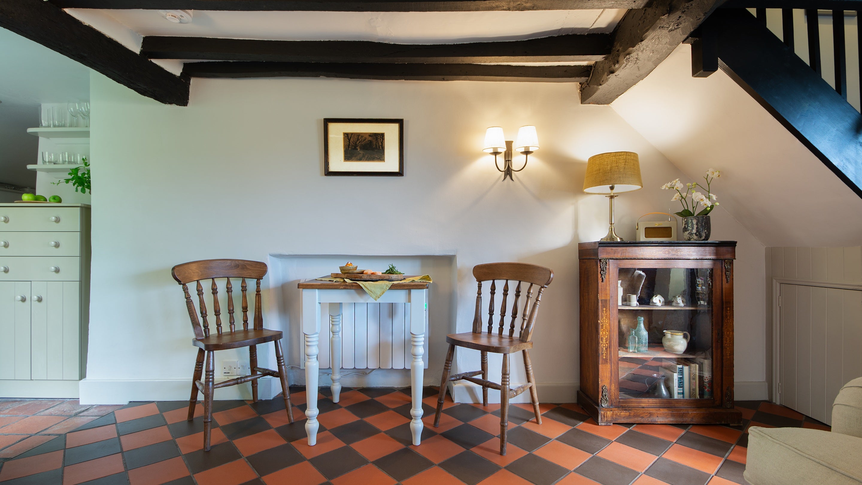 The dining area with table and chairs for two in the open-plan sitting and dining room at Spring Cottage, Gloucestershire