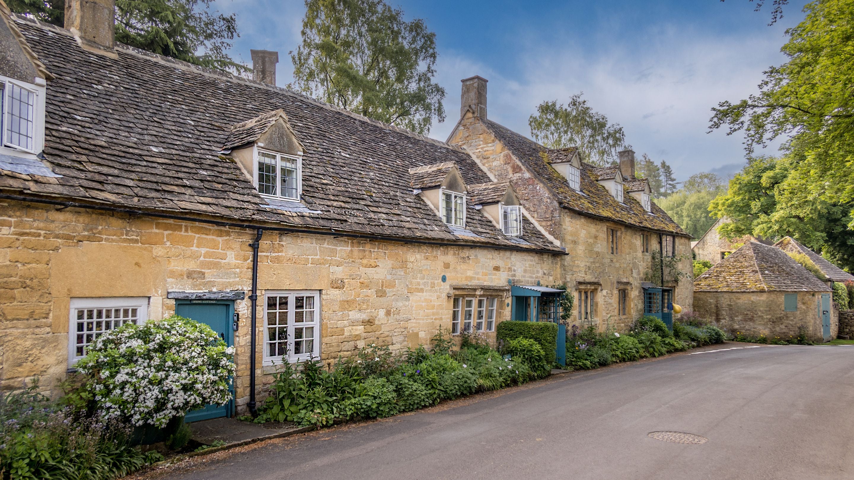 Looking along the village street at Spring Cottage and its neighbours, including Snowshill Manor Farmhouse, Gloucestershire