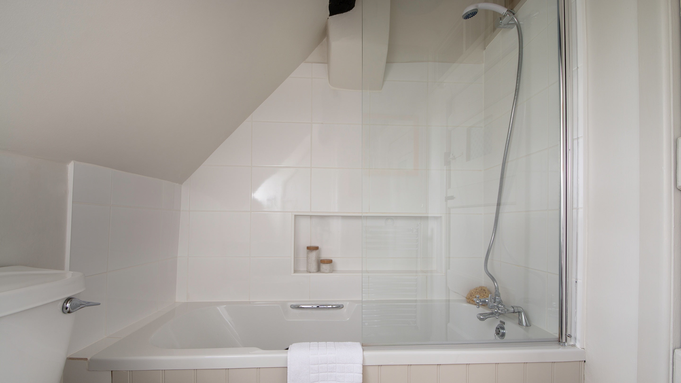 The bathroom with shower over bath at Spring Cottage, Gloucestershire