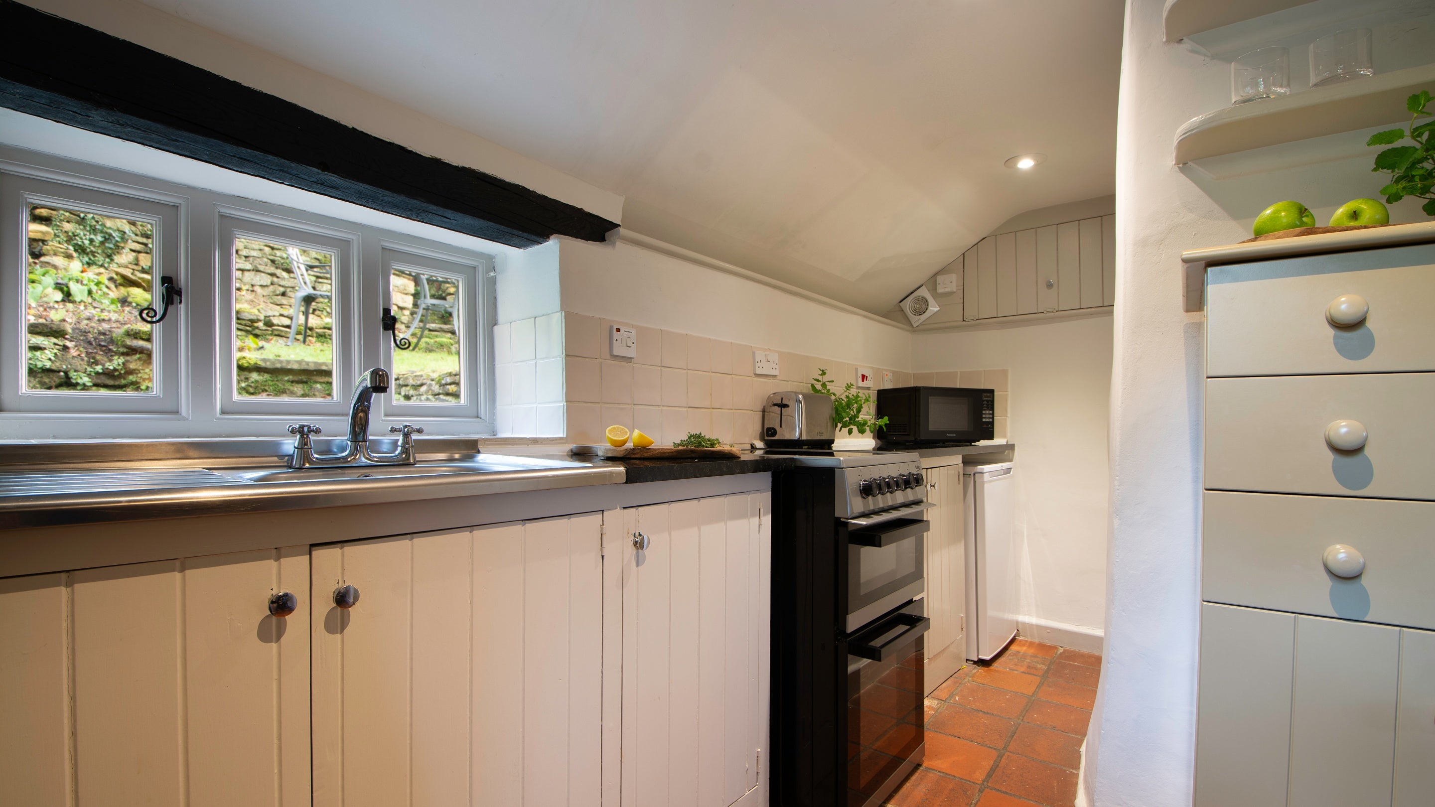 The kitchen with views of the rear garden at Spring Cottage, Gloucestershire