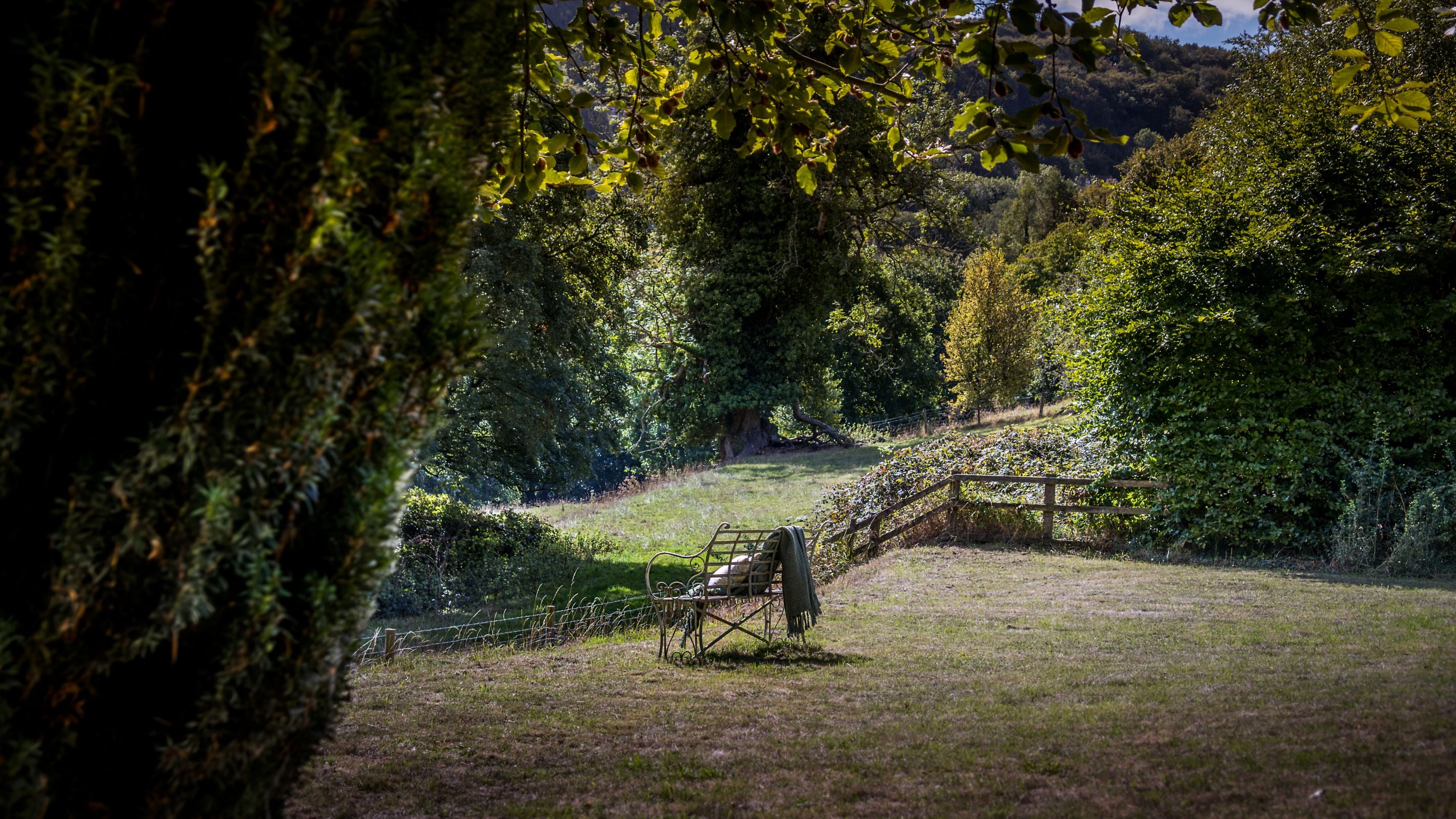 The garden lawn with bench at Woody's Cottage, Gloucestershire