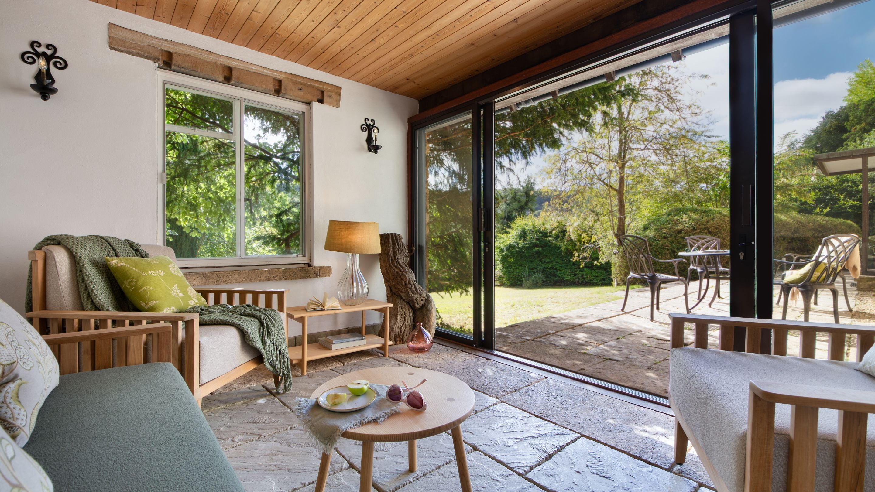 The garden room with sofa and two armchairs at Woody's Cottage, Gloucestershire