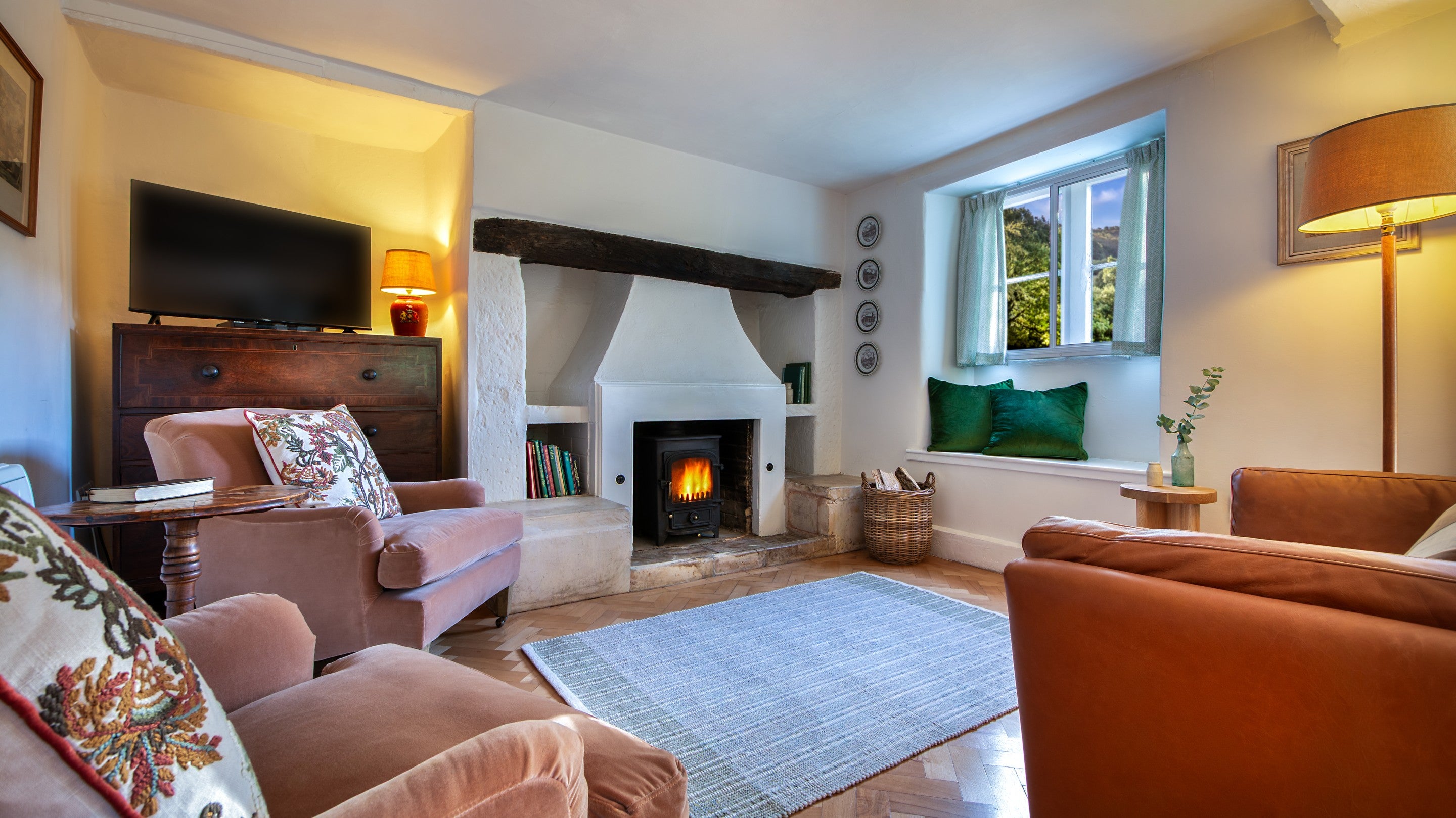 The sitting area in the open-plan sitting and dining room with woodburner at Woody's Cottage, Gloucestershire