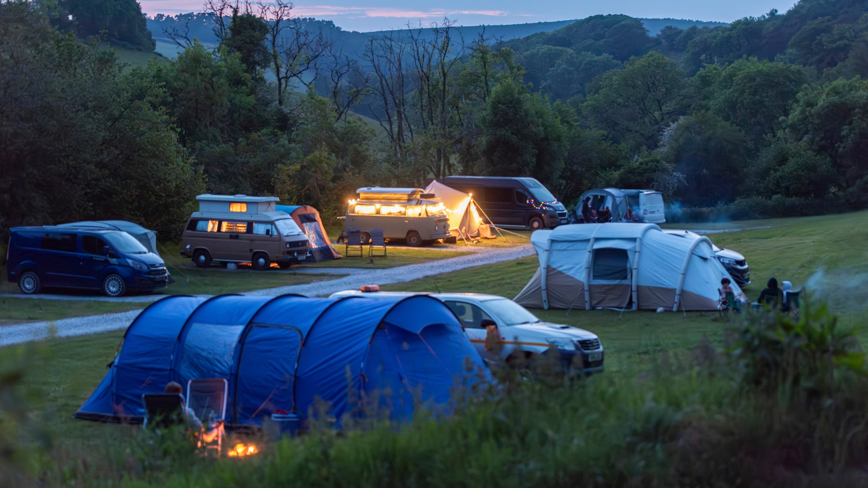 Campervans, motorhomes and tents at Cloud Farm Campsite in the evening, Devon