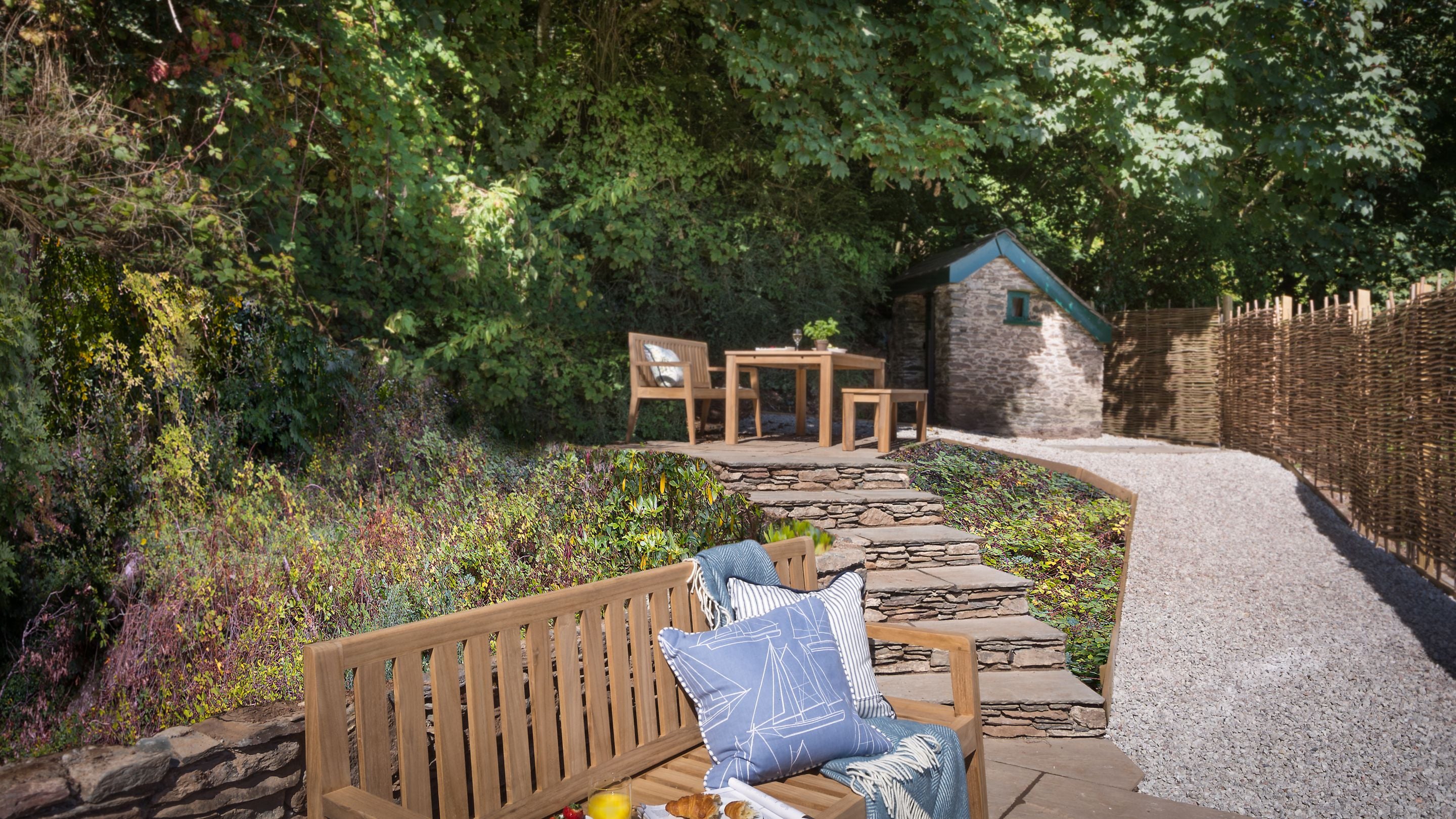The raised terrace garden at Compass Cottage backs onto woodland, Devon