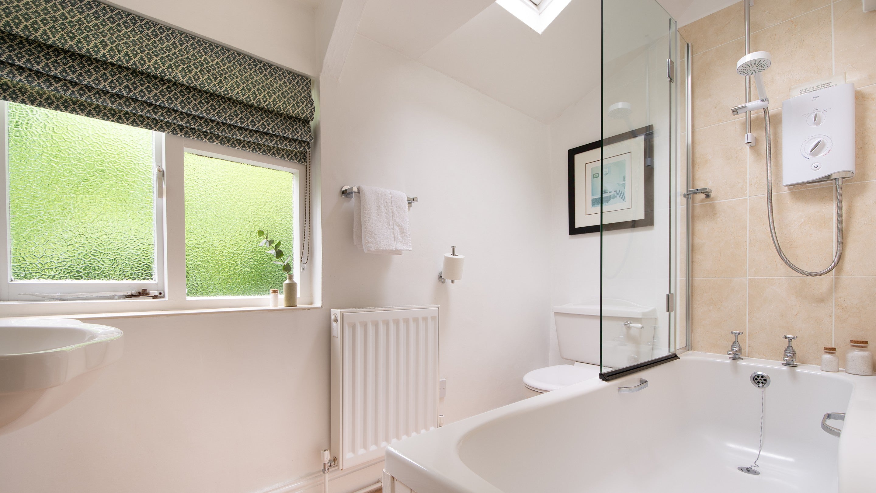 The bathroom with shower over bath at Crockers Cottage, Devon